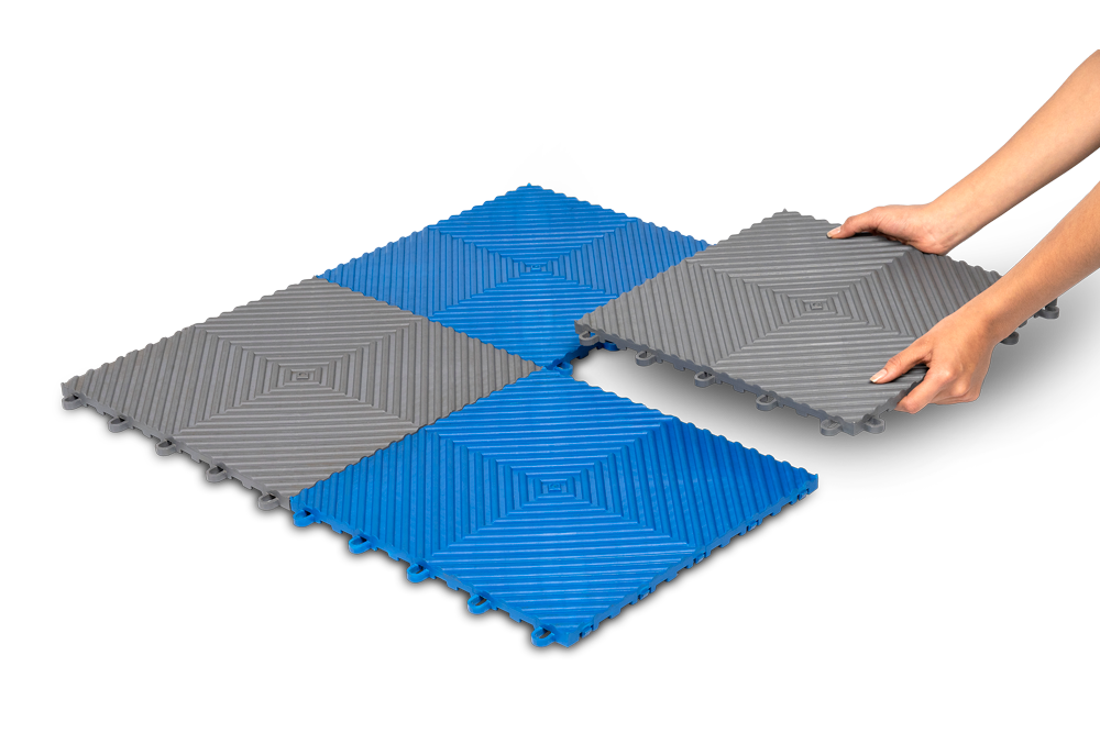 Una persona sostiene un azulejo azul y gris en sus manos.