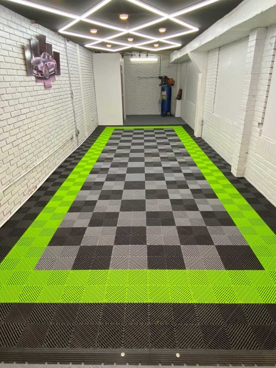 Un pasillo largo con suelo cuadriculado y borde verde.