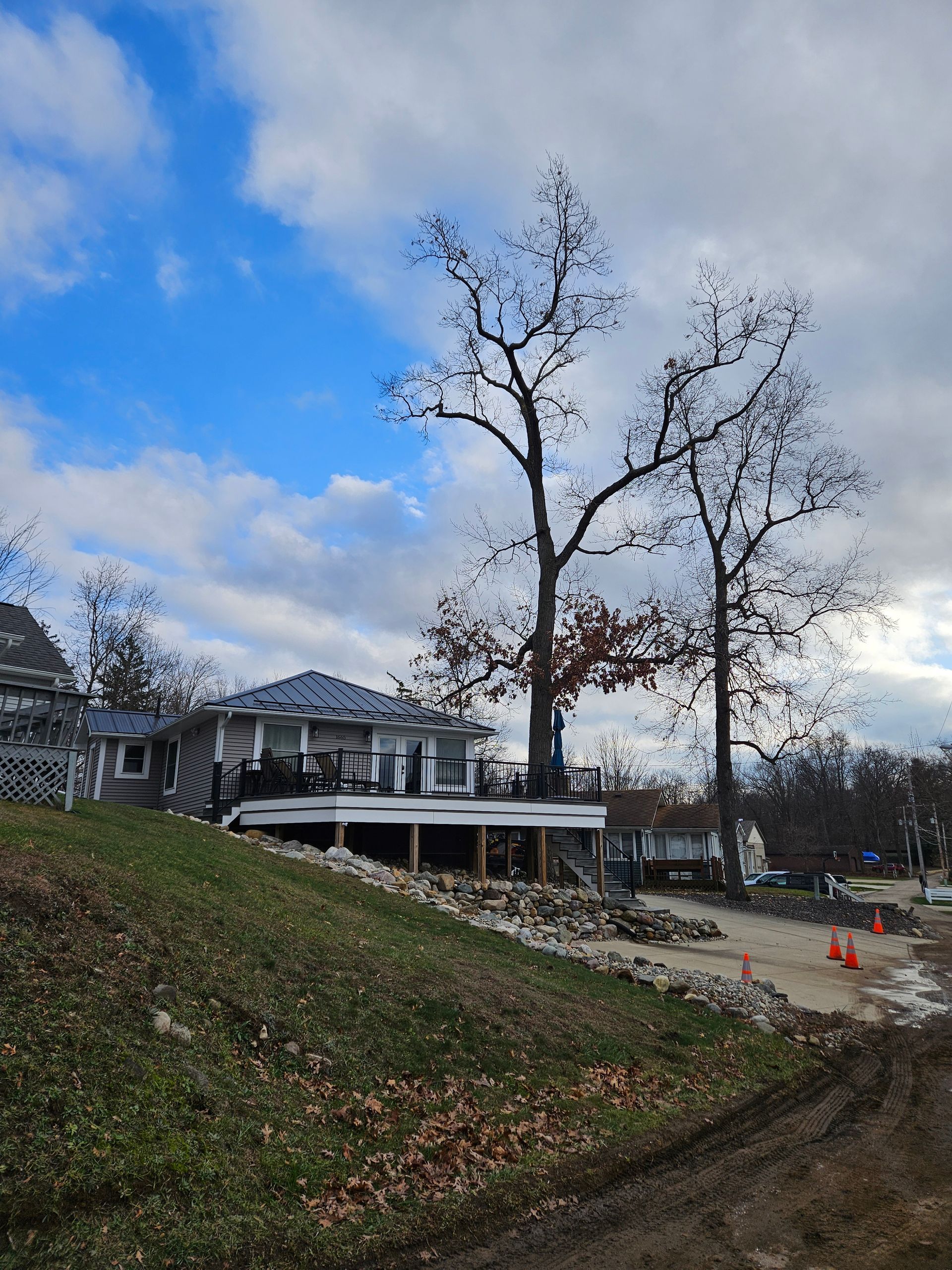 A house is sitting on top of a hill next to a tree.