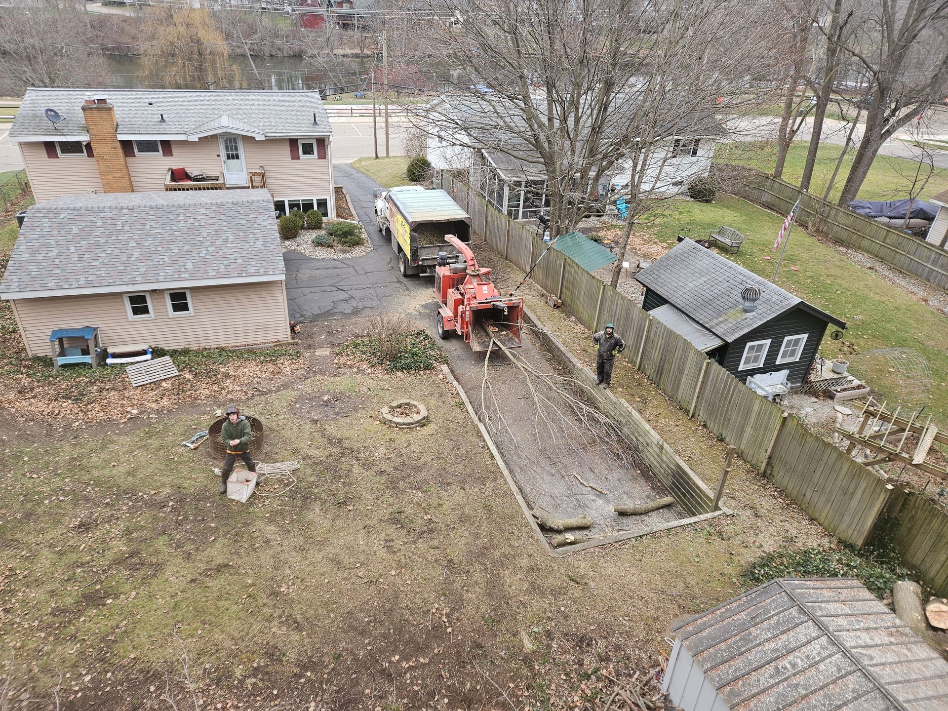 An aerial view of a house with a tree chipper in the backyard.