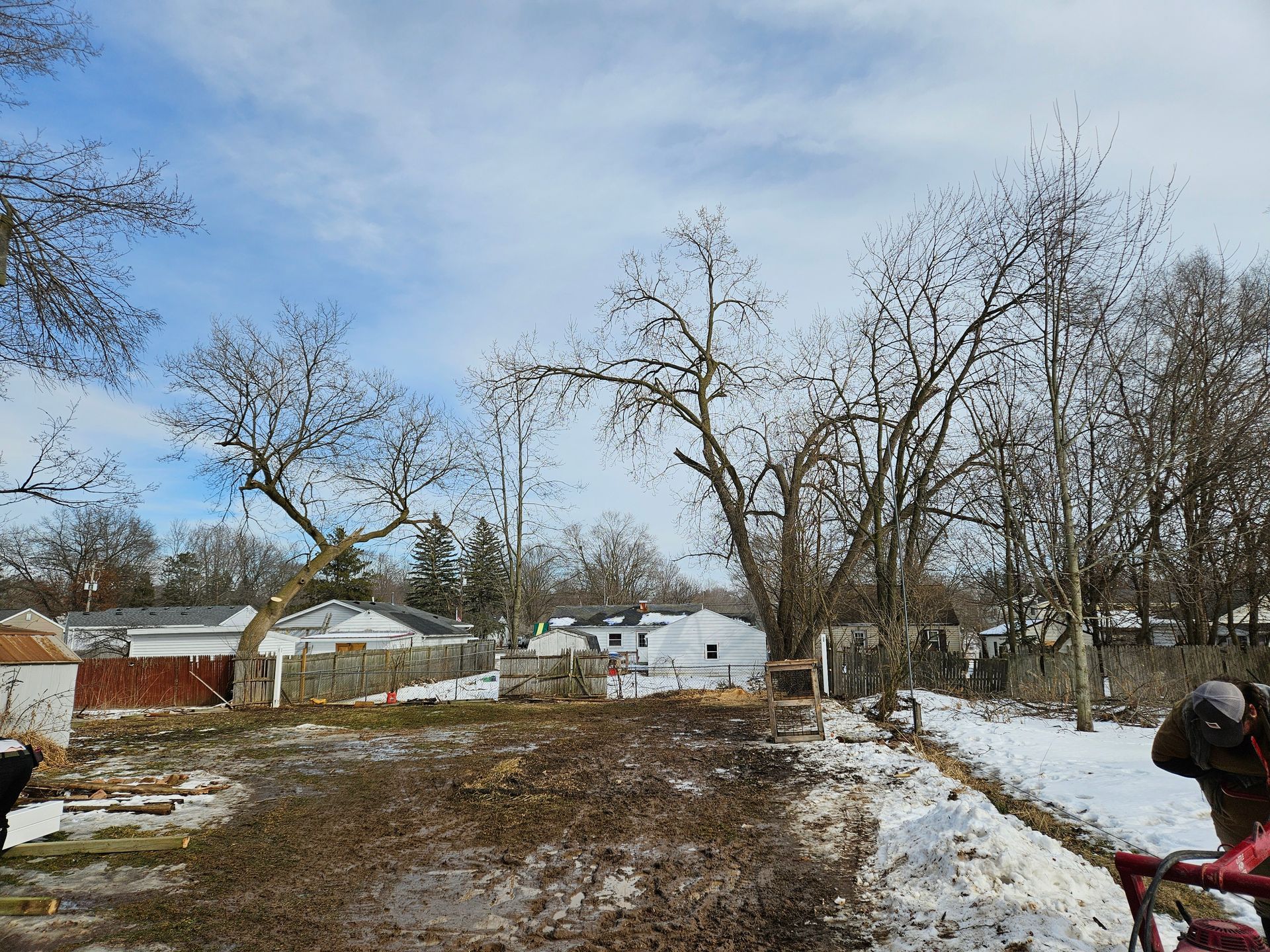 A person is using a snow blower to remove snow from a yard.