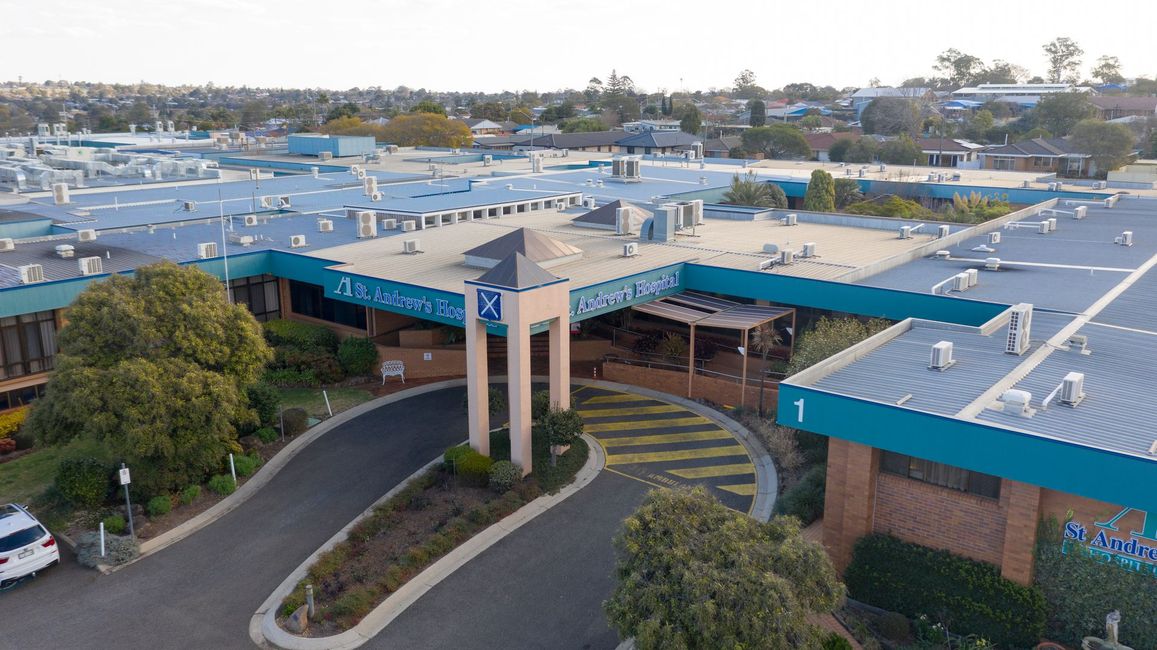 An aerial view of a large building with a car parked in front of it.