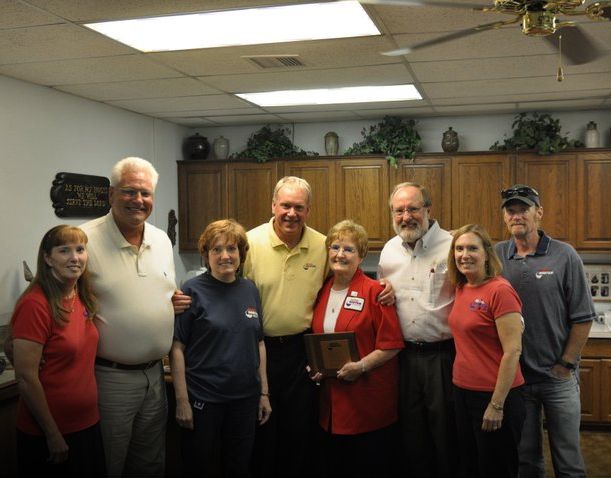 A group of people posing for a picture in a kitchen
