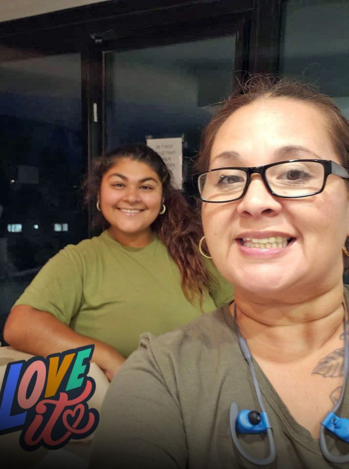 A man is standing in a flooded yard next to a truck.