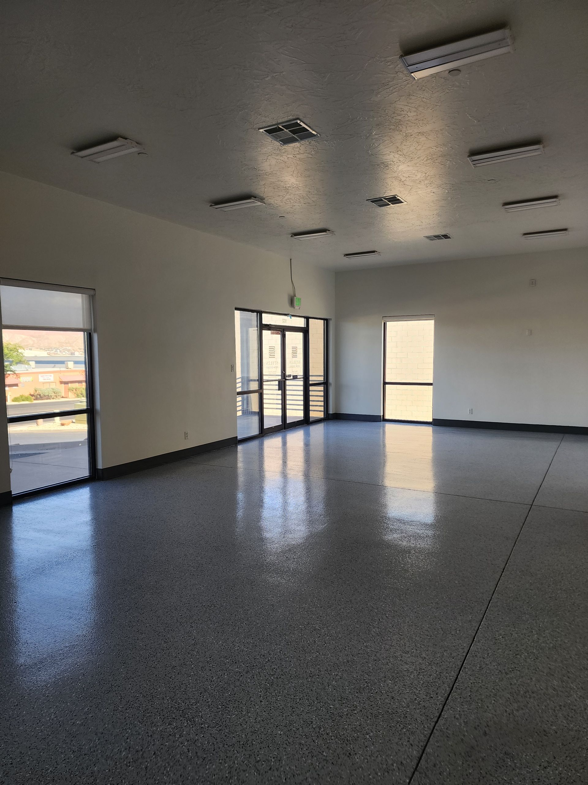 A large empty room with a gray floor and white walls