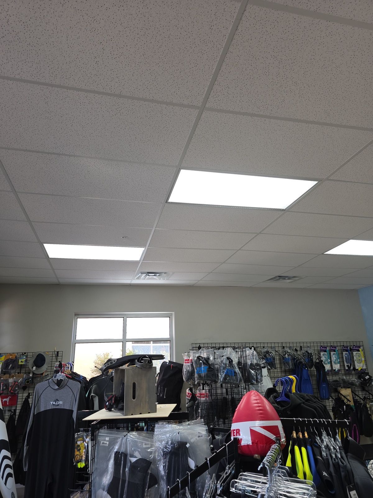 A store filled with lots of clothes and a football on a shelf.