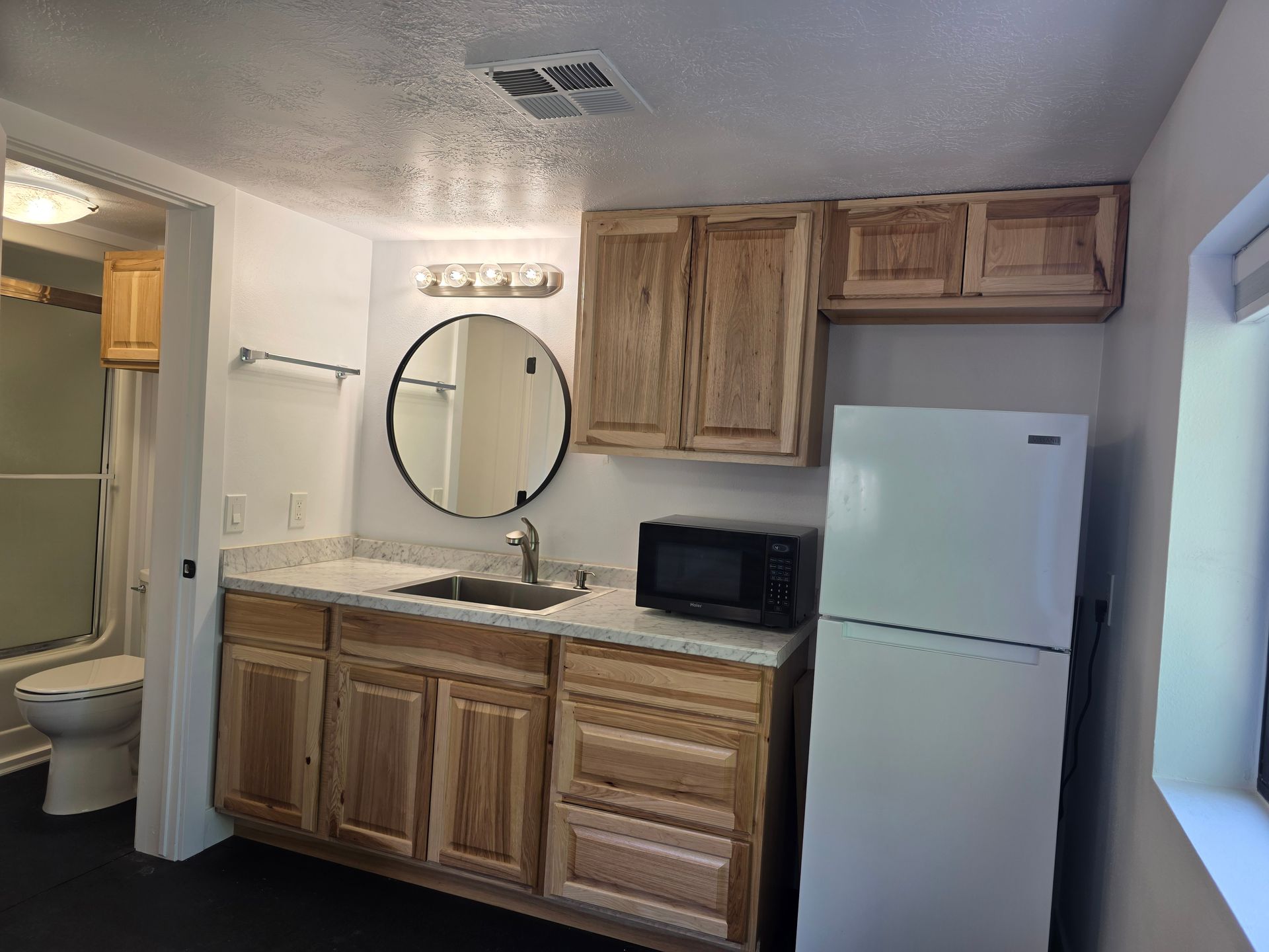 A bathroom with a sink , microwave and refrigerator