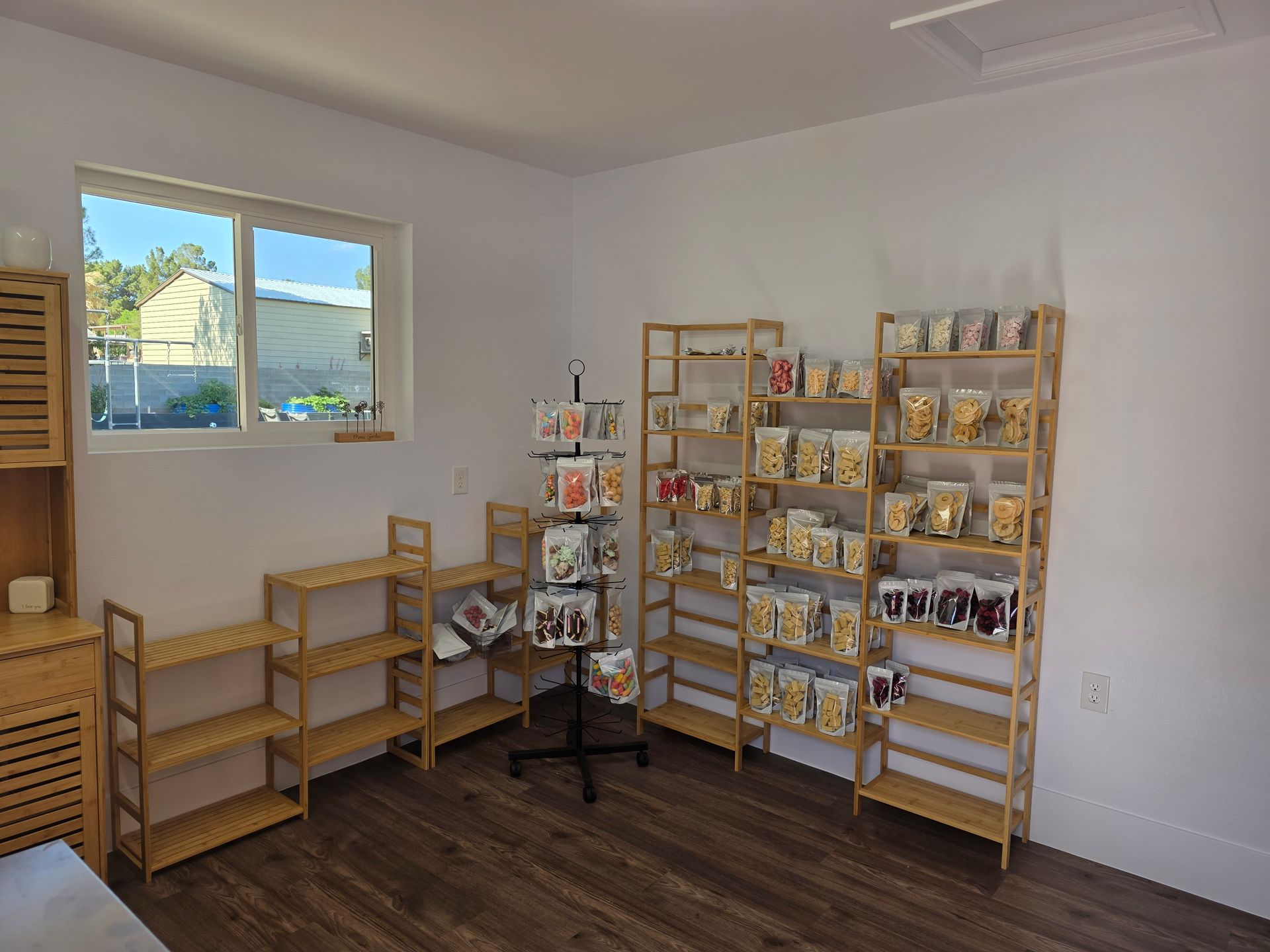 A room with a lot of shelves and a window.