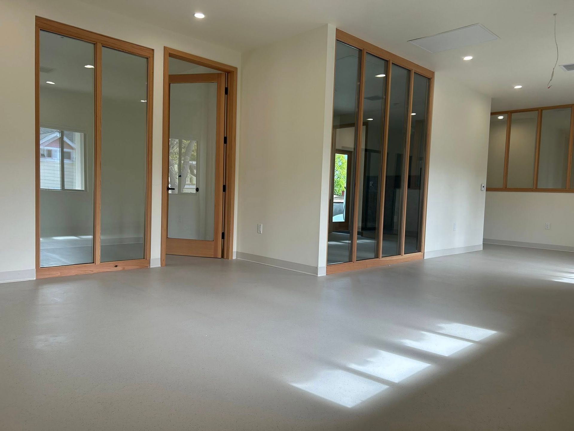 A home office with blue walls, a desk with a chair, a white console table, and a patterned accent chair on beige carpet.