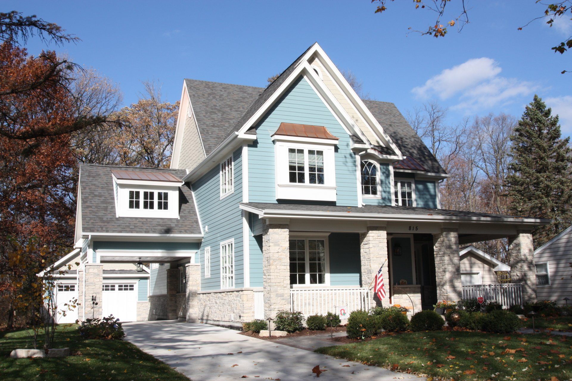 A blue house with a gray roof and white trim