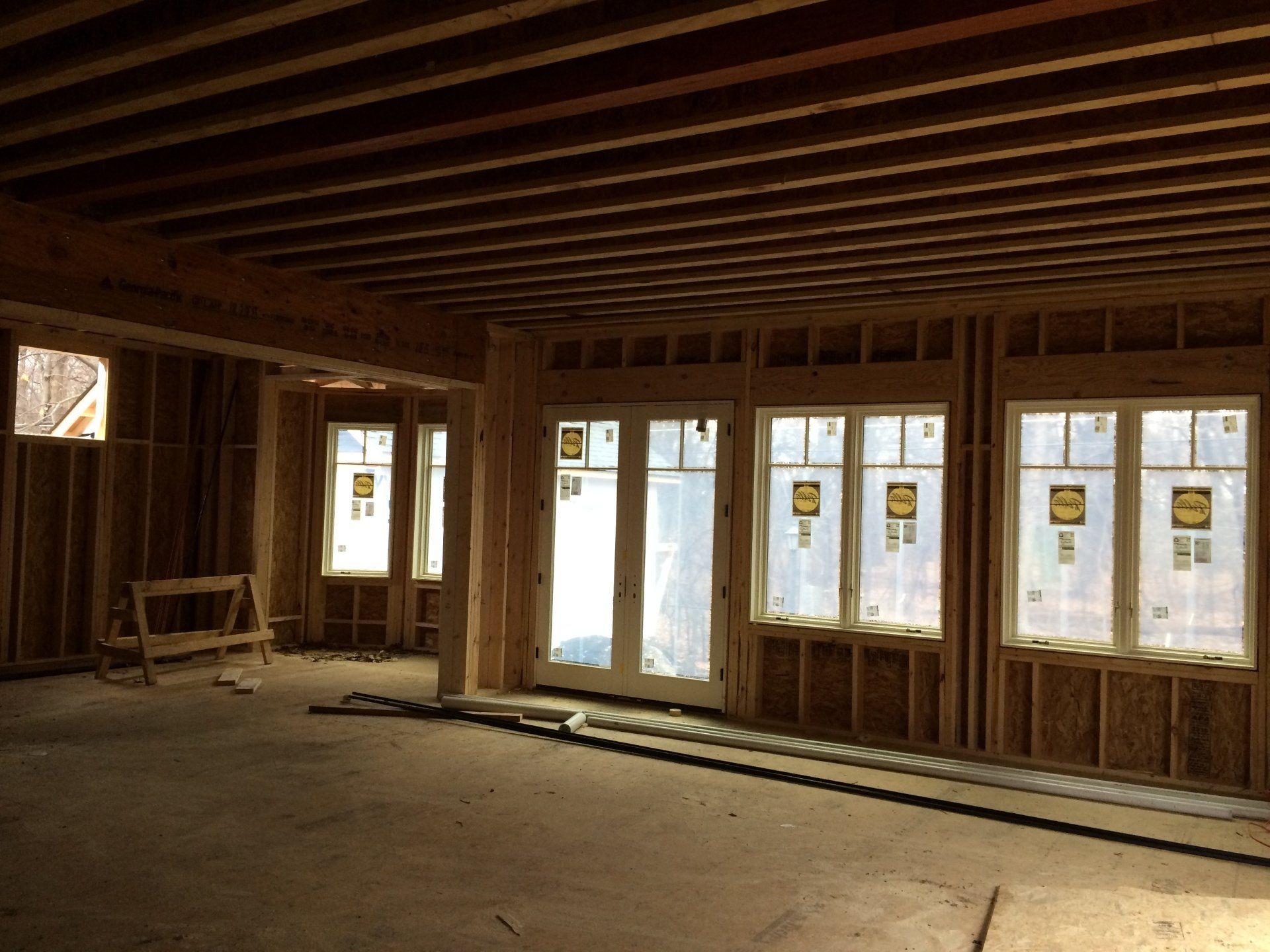 A room in a house under construction with lots of windows