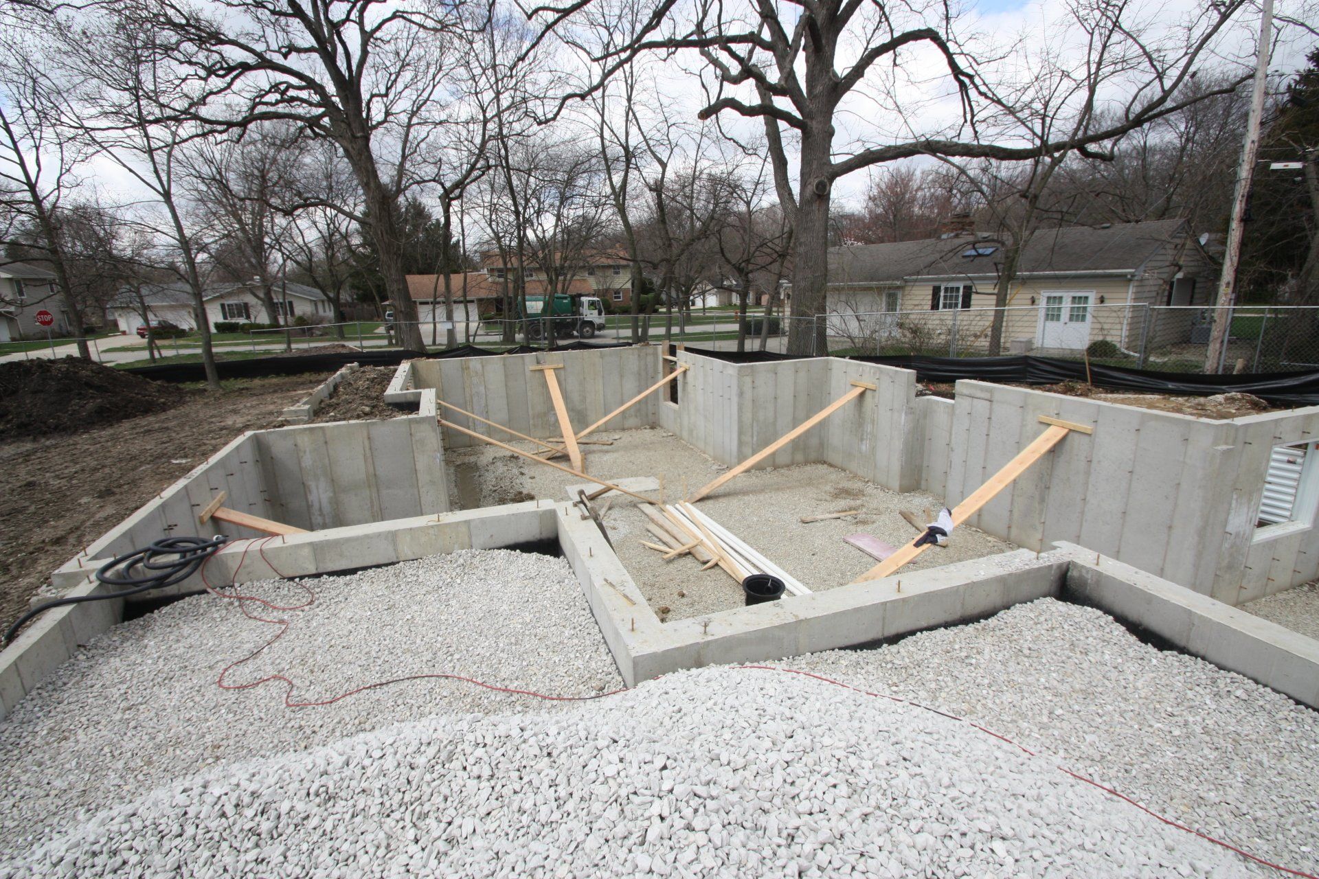 A concrete foundation is being built in front of a house
