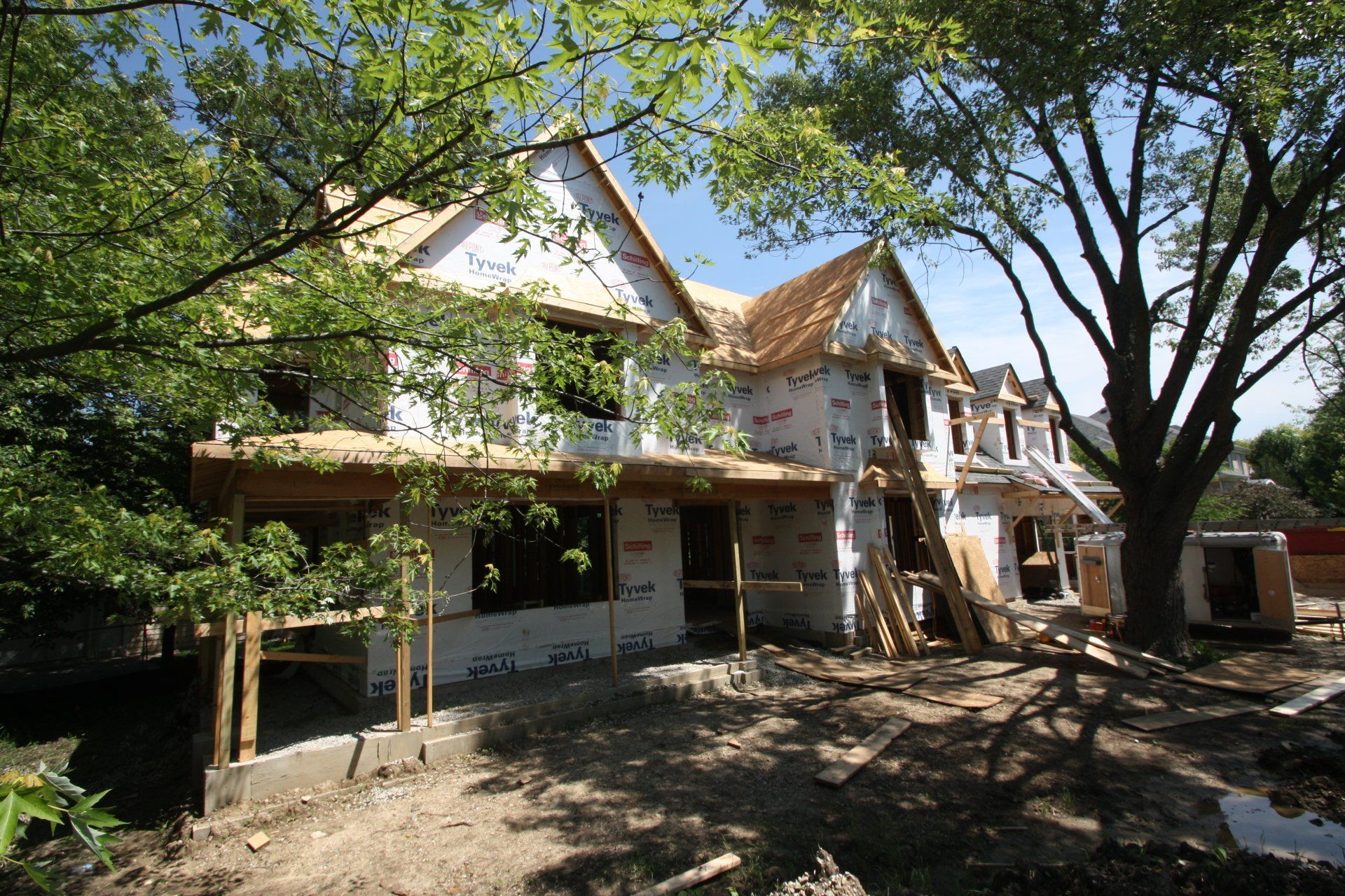 A house that is being built with a lot of trees in front of it
