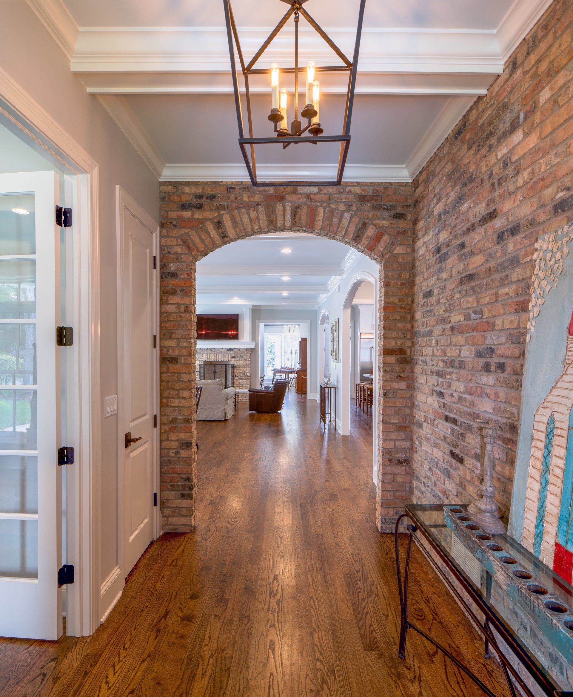 A hallway with a brick wall and a chandelier