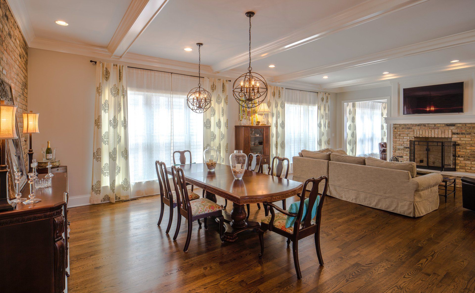 A living room with a dining table and chairs and a fireplace.