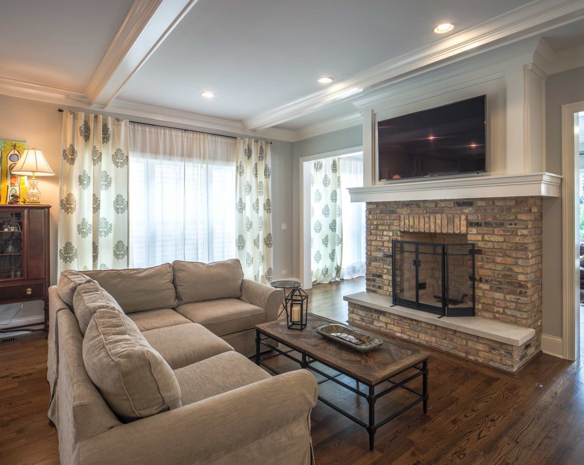 A living room with a fireplace , couch , coffee table and television.