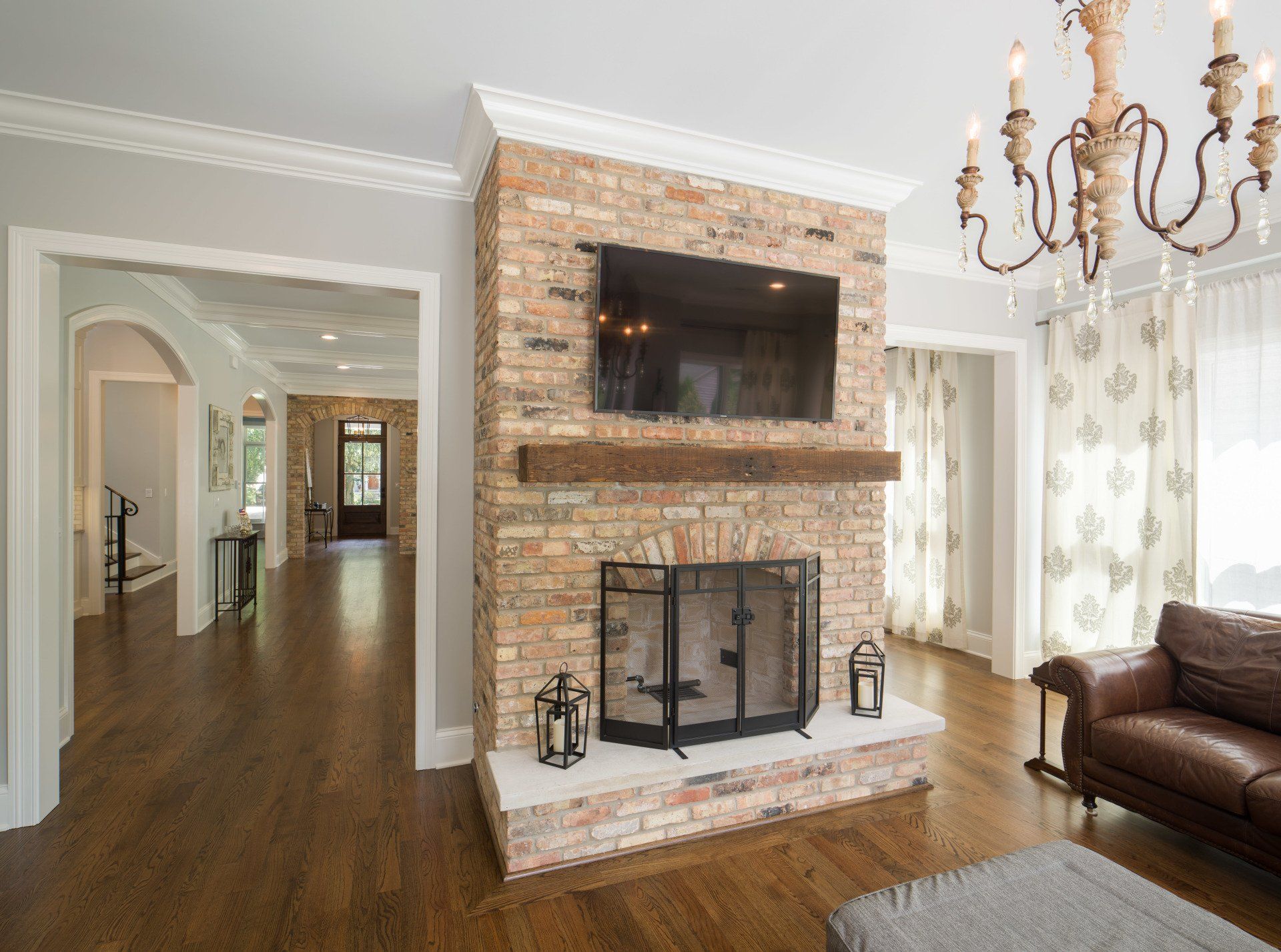 A living room with a fireplace and a flat screen tv on the wall.