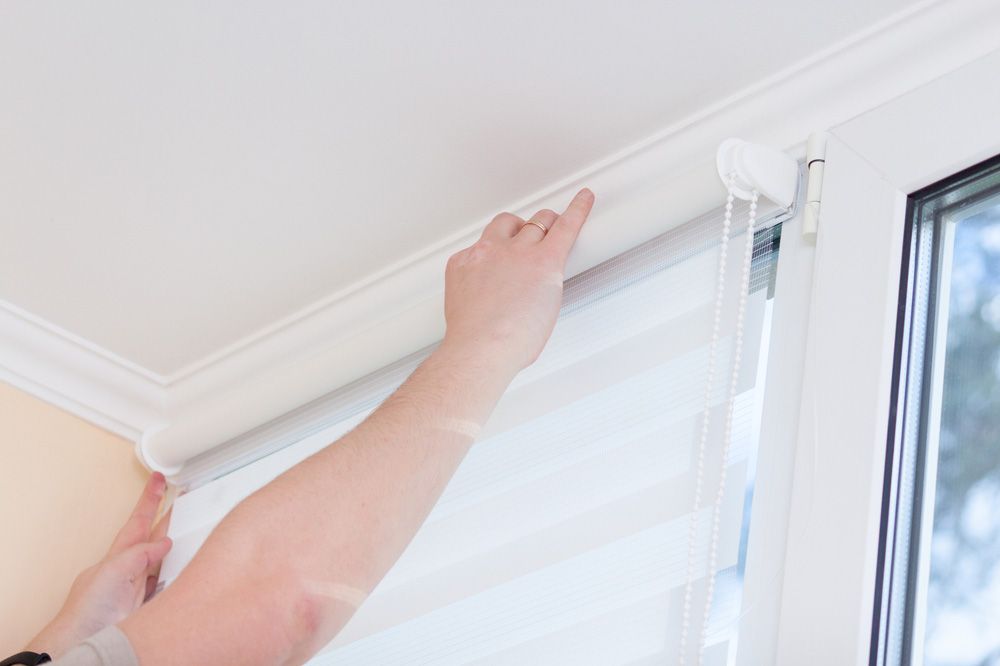 Worker Cleaning a Roller Blinds — Window Furnishing Services in Gold Coast, NSW