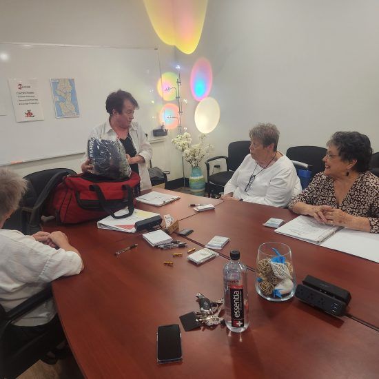 A group of people are sitting around a table with a bottle of minute maid on it