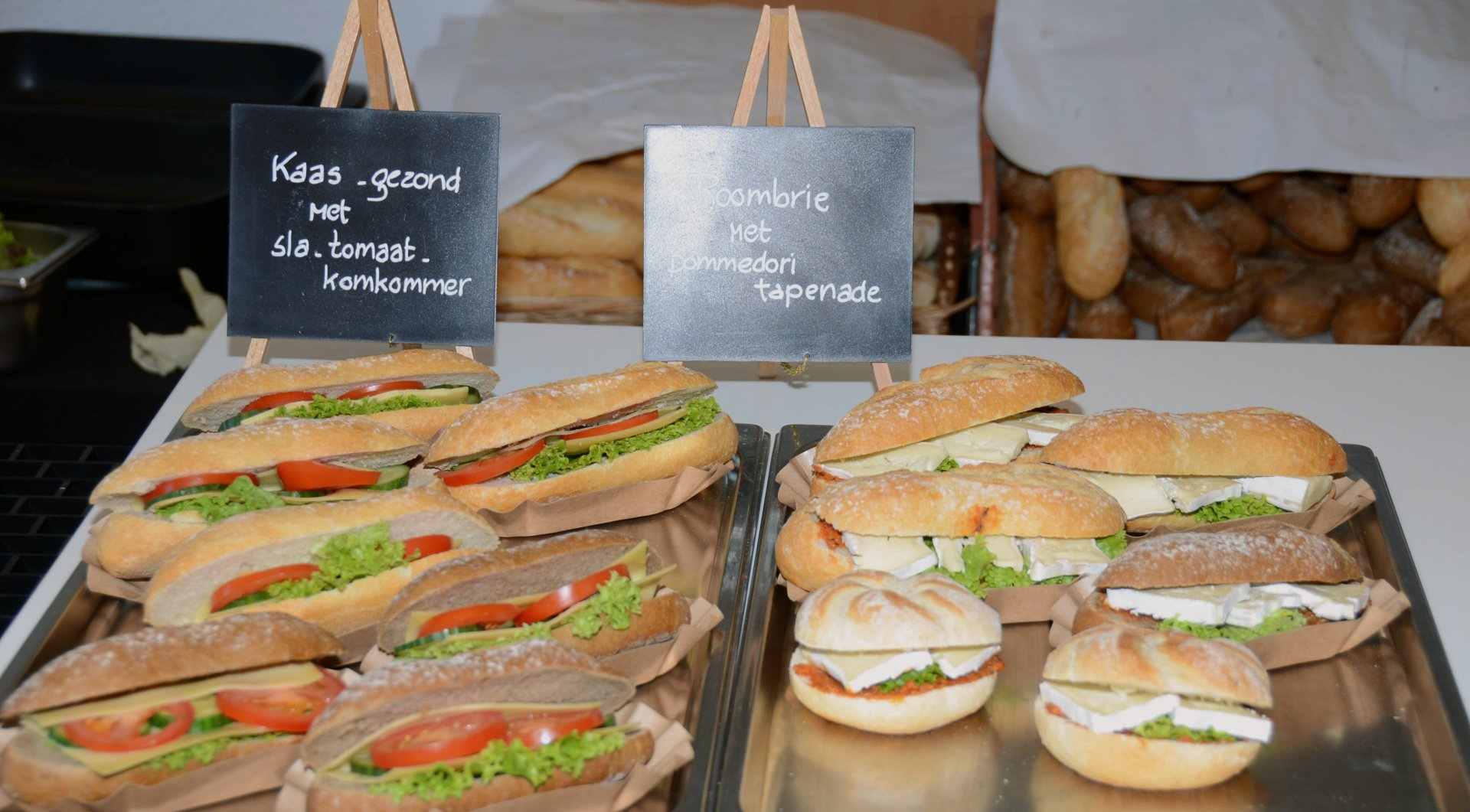 Sandwiches worden op een dienblad uitgestald, met bordjes waarop staat welke vullingen er op de broodjes zitten.