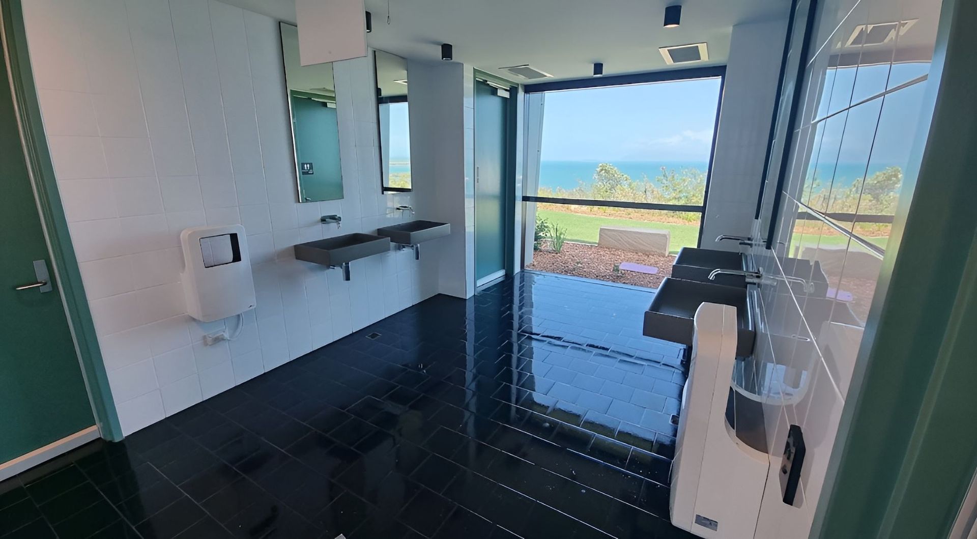 A Bathroom With Two Sinks and a Large Window With a View of the Ocean — Kristal Kleen Services in Jubilee Pocket, QLD