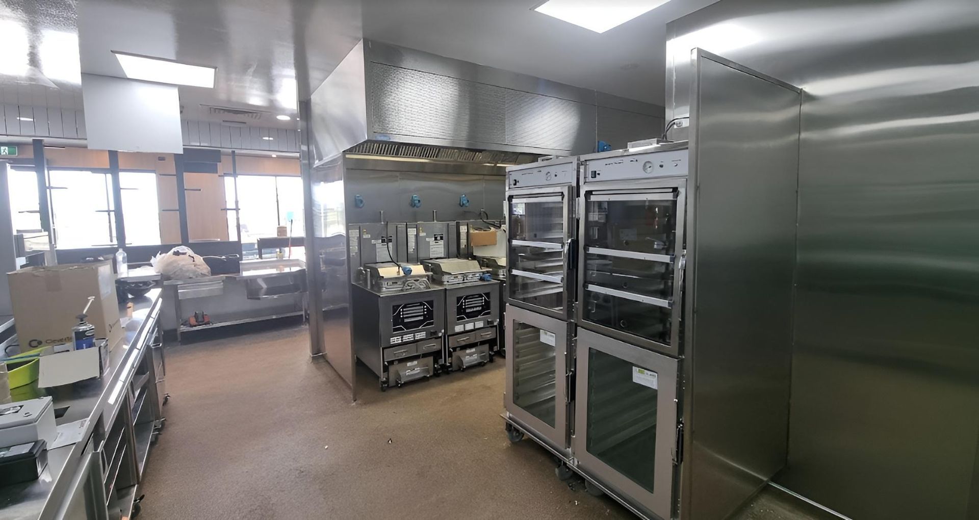 A Large Kitchen With a Lot of Stainless Steel Appliances — Kristal Kleen Services in Jubilee Pocket, QLD
