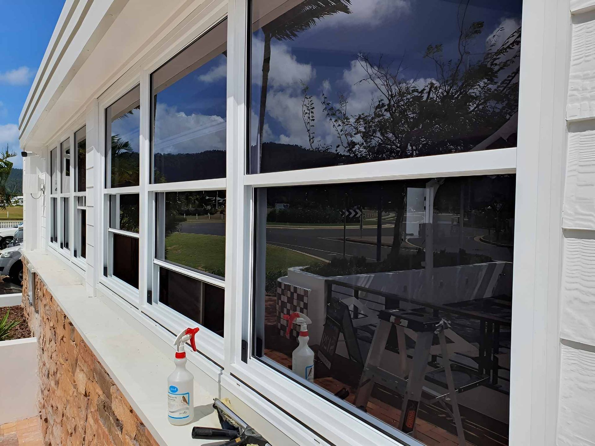 A White House With a Lot of Windows and a Spray Bottle on the Window Sill — Kristal Kleen Services in Jubilee Pocket, QLD
