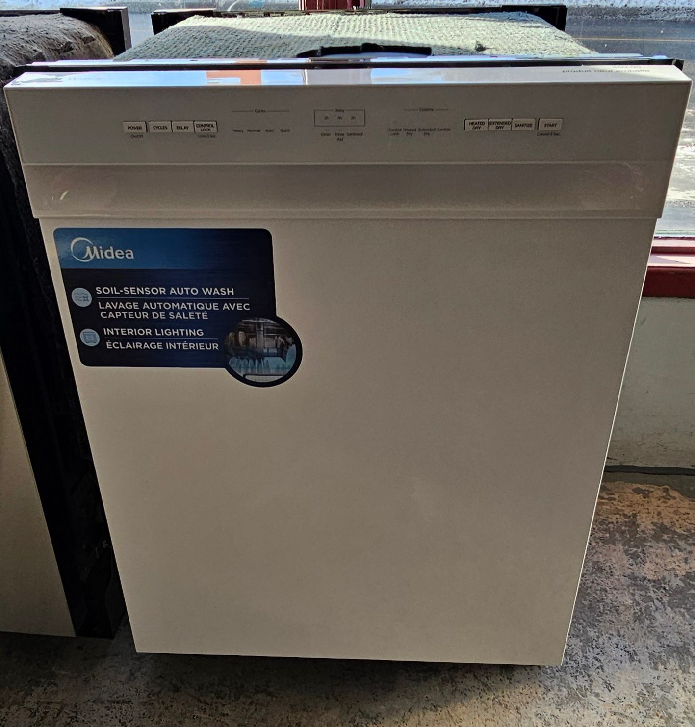 Lave-vaisselle Midea blanc avec panneau de commande et étiquette produit.