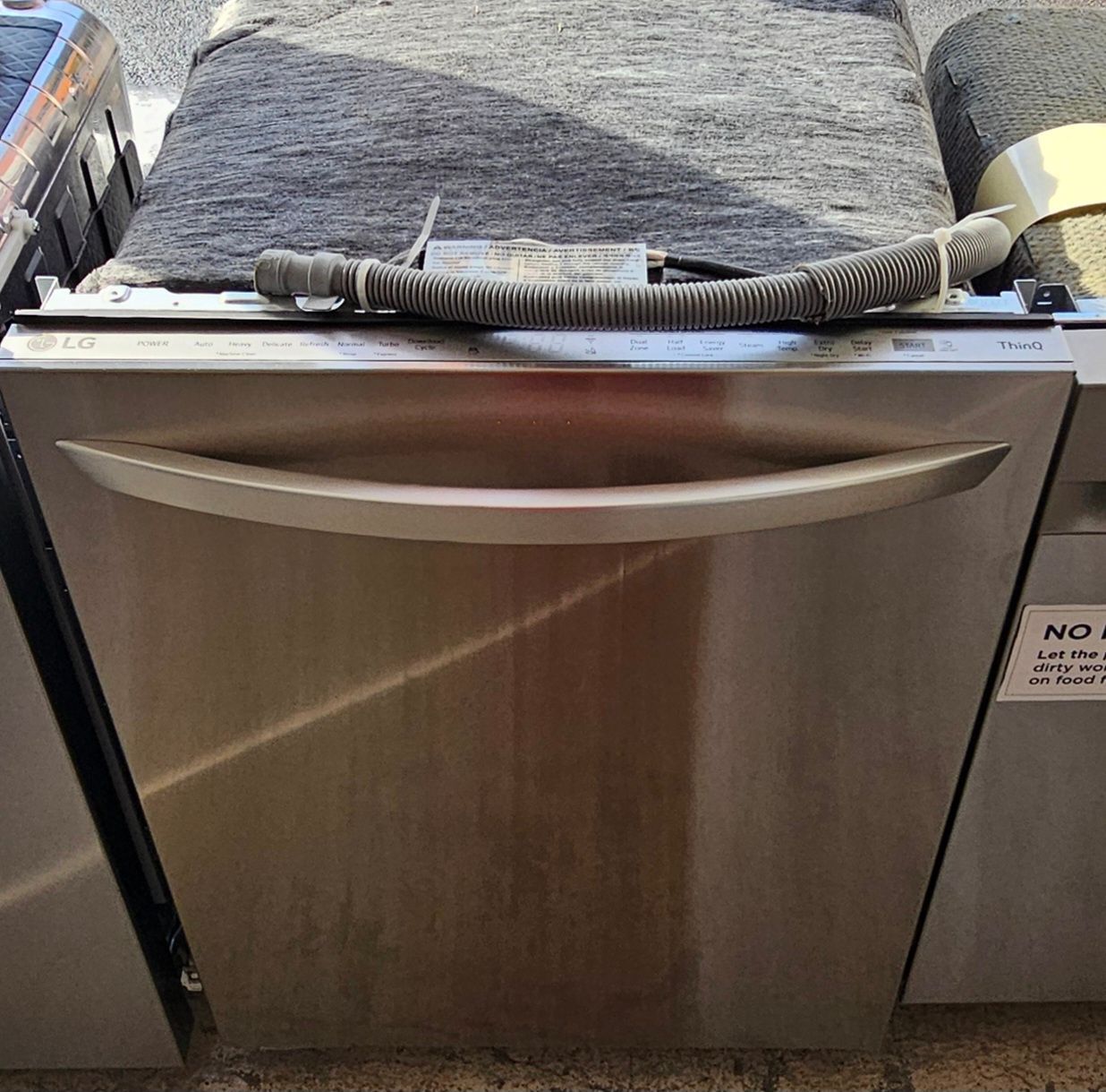 Lave-vaisselle en acier inoxydable avec poignée incurvée.