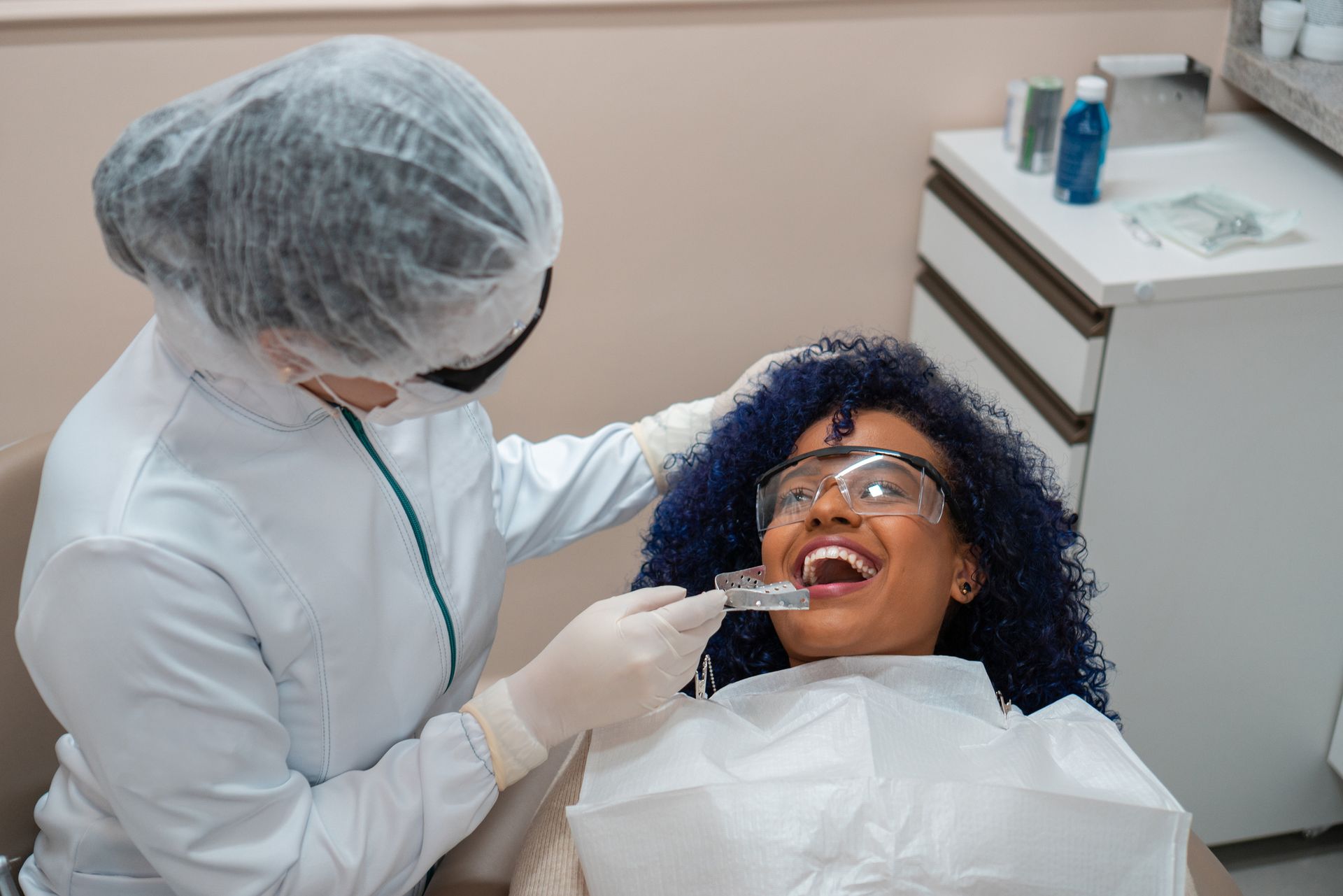 A woman smiling in a dental chair during a general dentistry check-up with her general dentist.