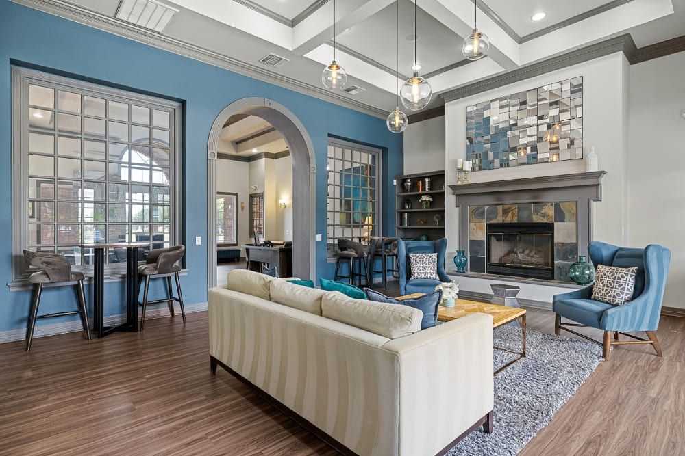 Clubhouse with modern furniture like couch, chairs, and a fireplace at Marquis at Town Centre in Broomfield, CO.