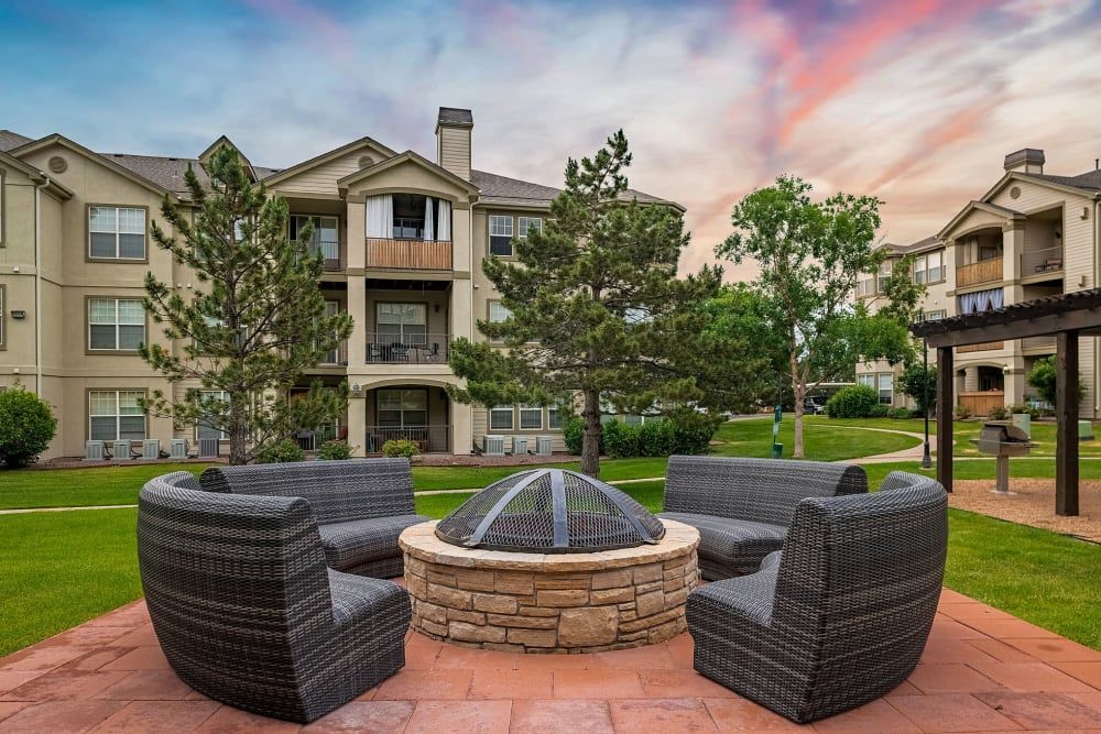 A fire pit surrounded by wicker furniture at Marquis at Town Centre in Broomfield, CO.