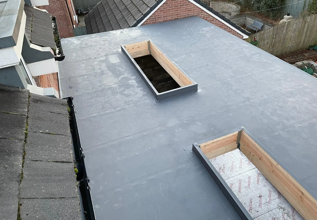 A picture of a ceiling joists being covered with plywood by Roofers Manchester