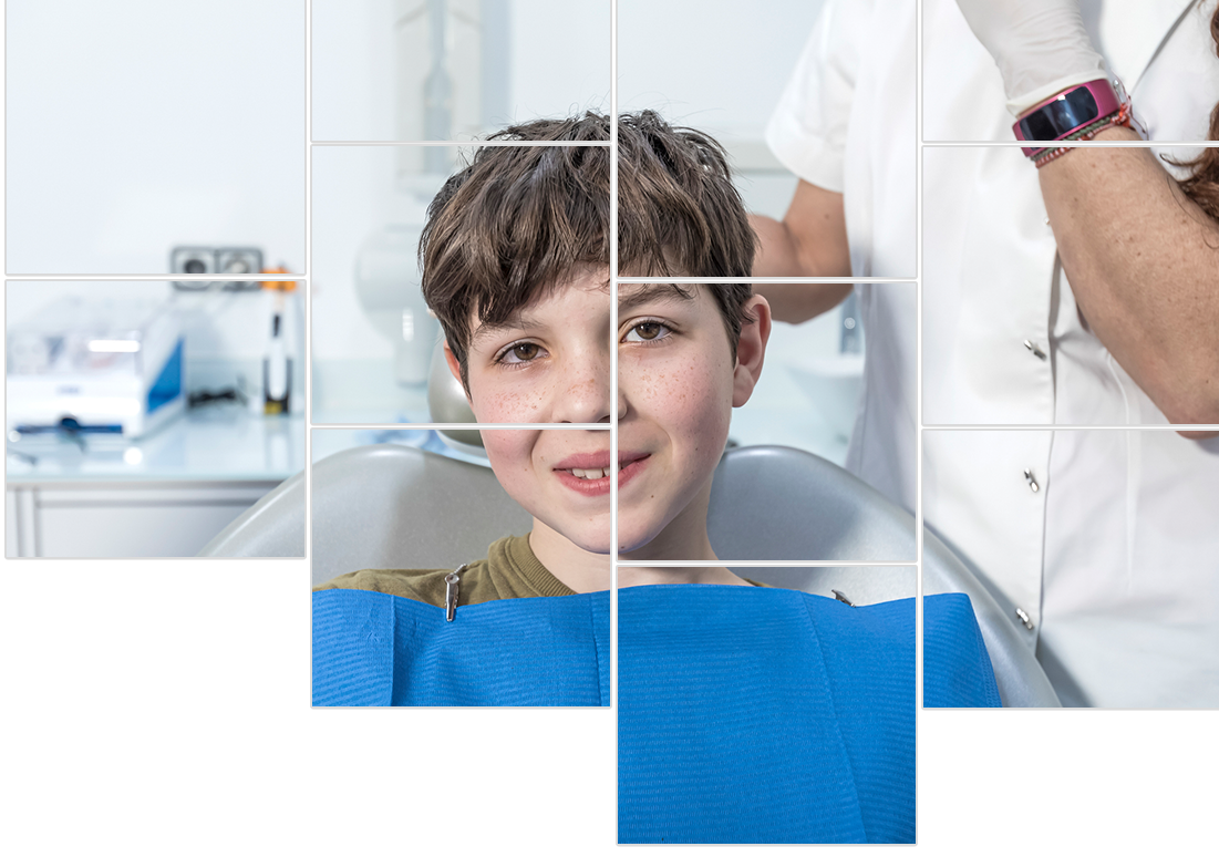 A young boy is smiling while sitting in a dental chair.