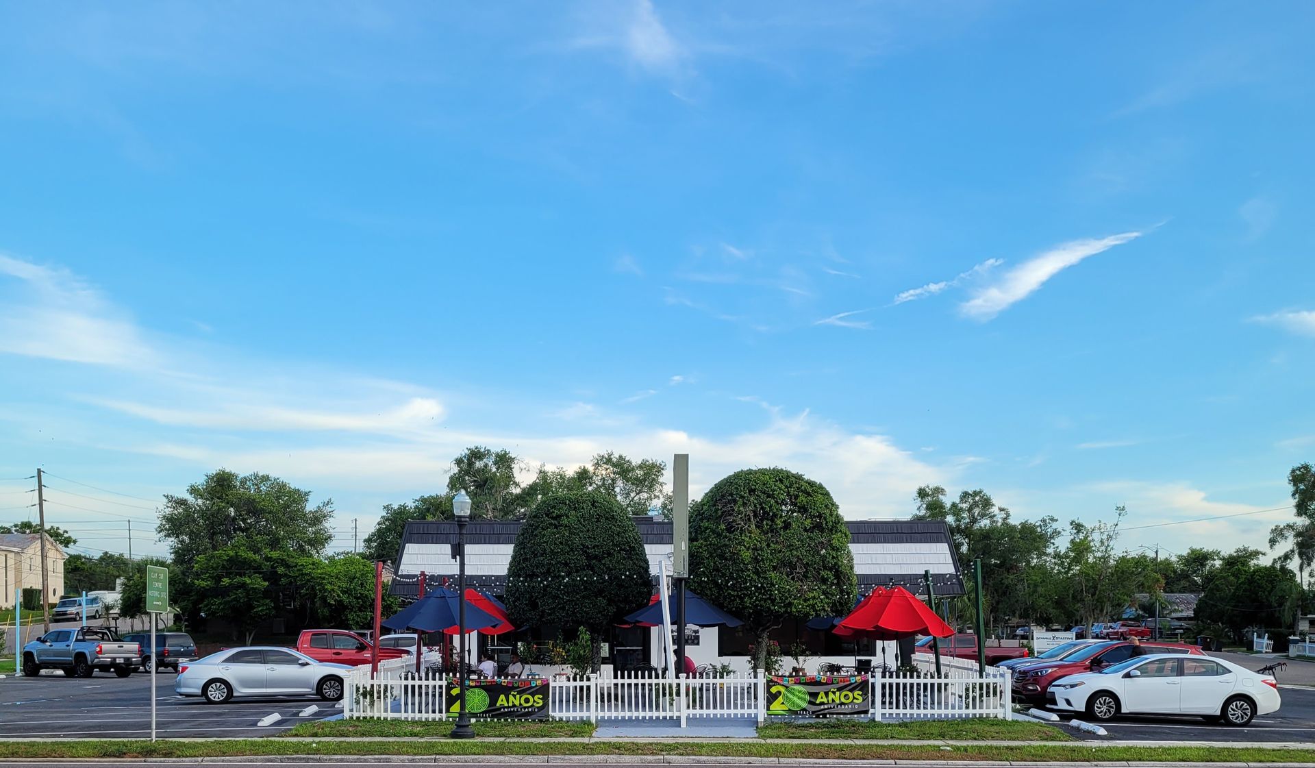 A parking lot with cars parked in front of a restaurant.