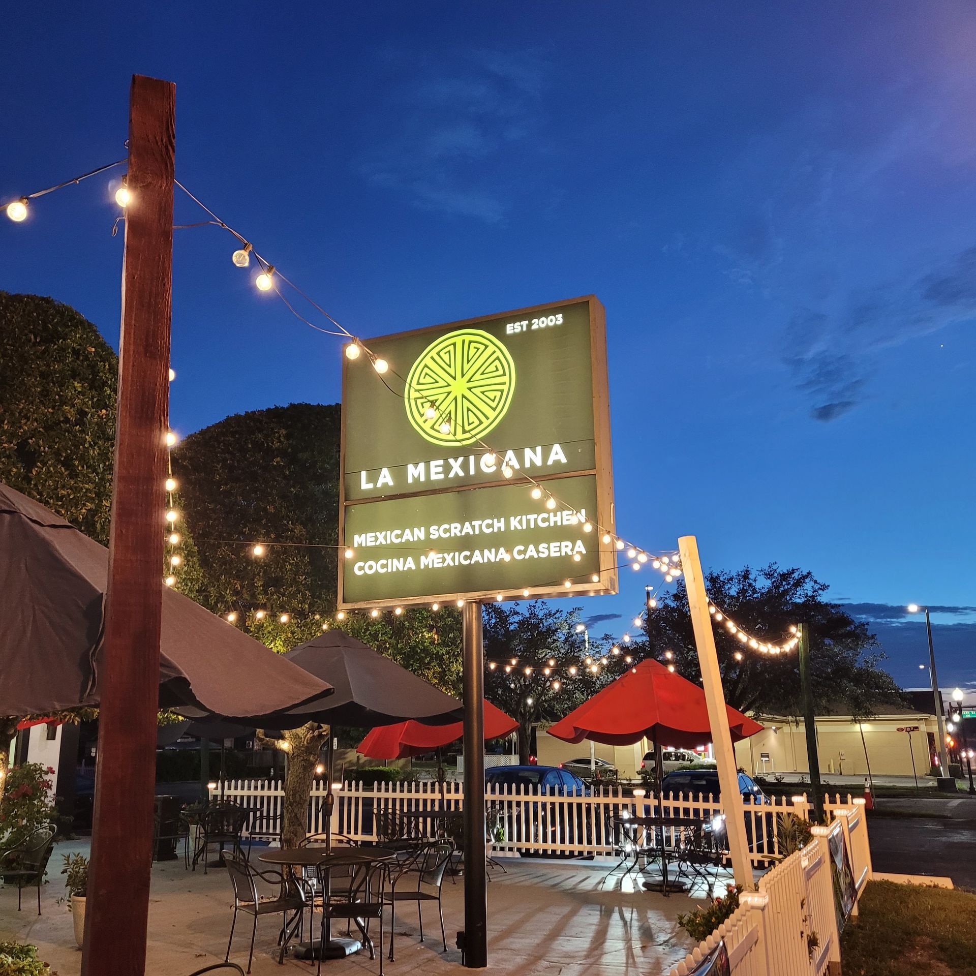 A sign for la mexicana is lit up at night