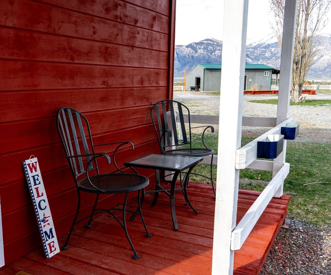 A porch with chairs and a welcome sign on it