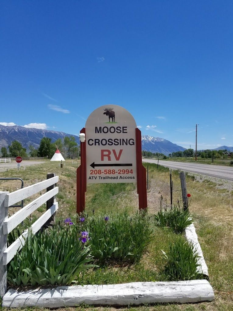 A sign that says moose crossing rv on it