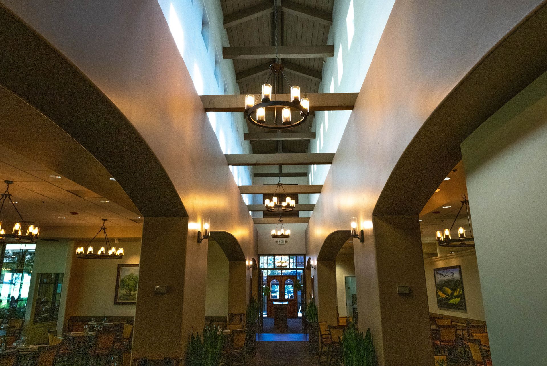 A long hallway with a chandelier hanging from the ceiling.