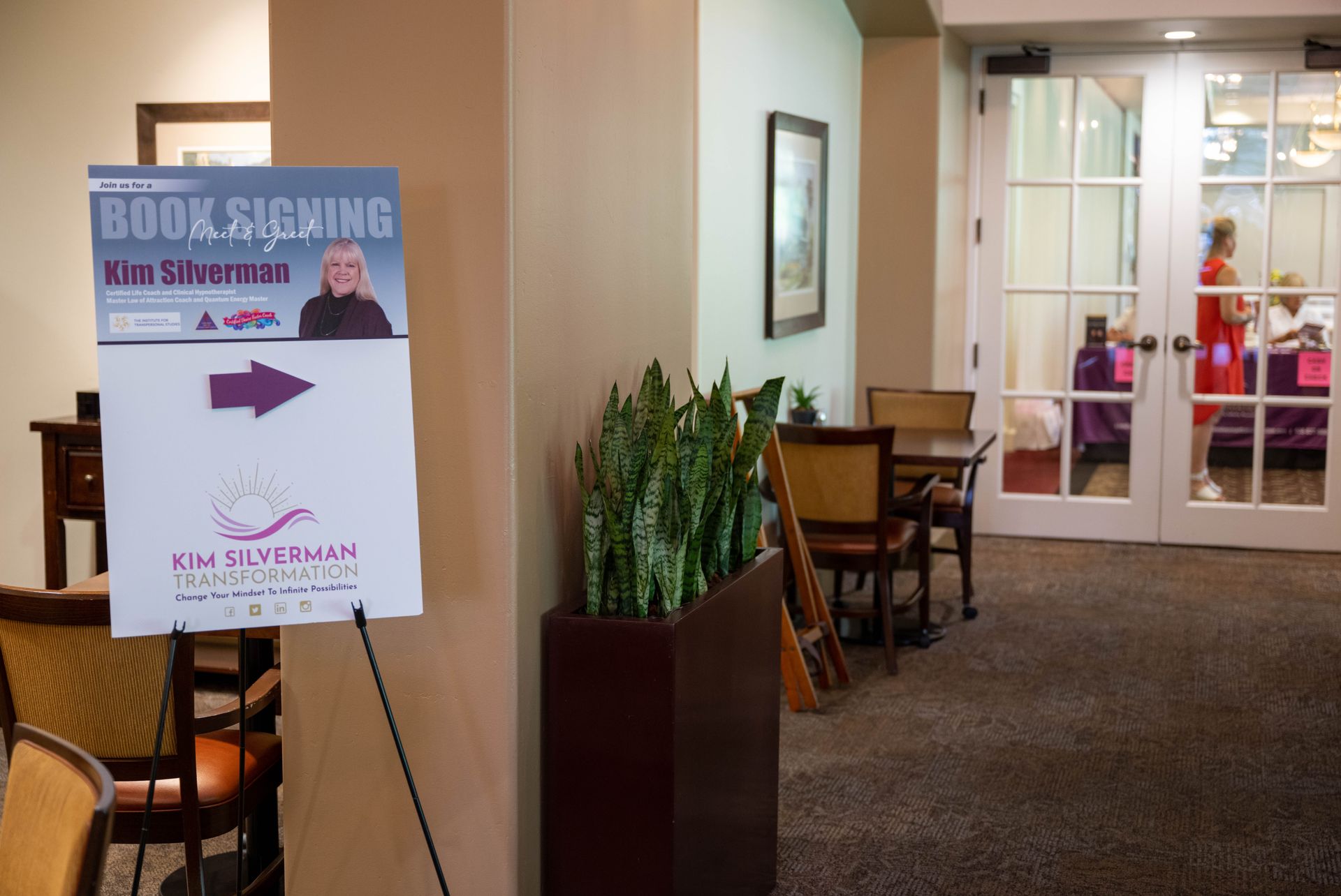 A room with a sign that says book signing kim silverman