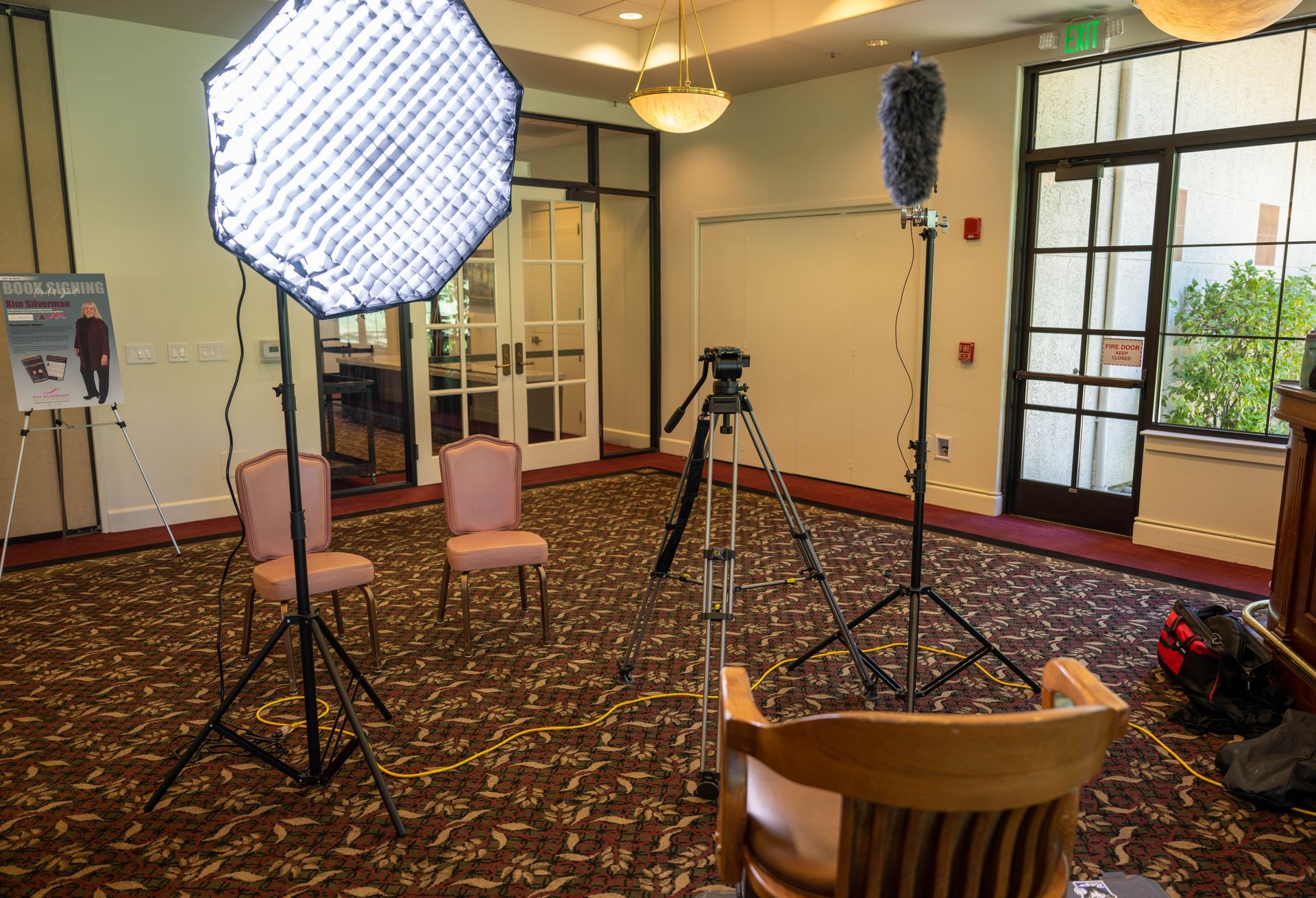 A room with two chairs and a camera on a tripod.