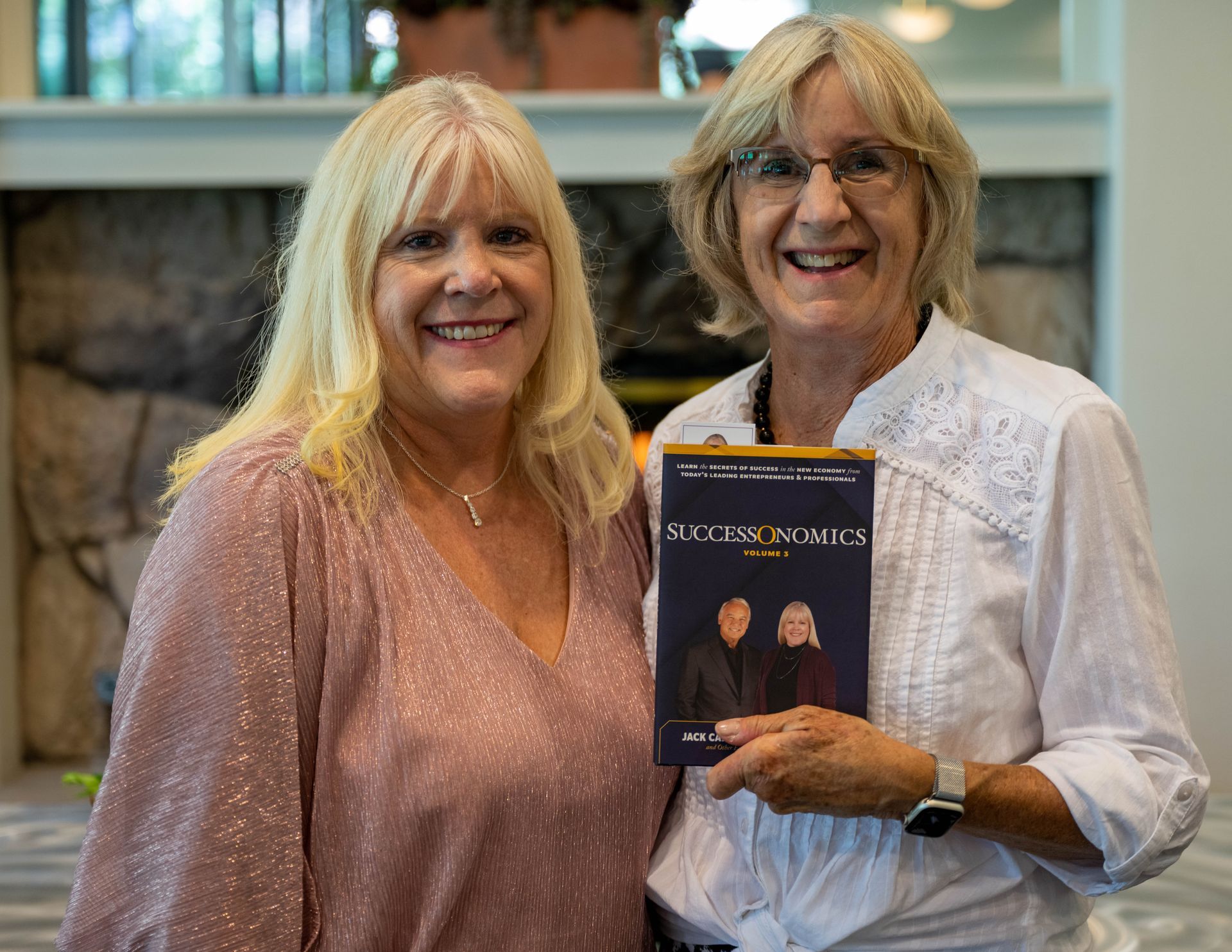 Kim Silverman and a women are standing next to each other holding a book.