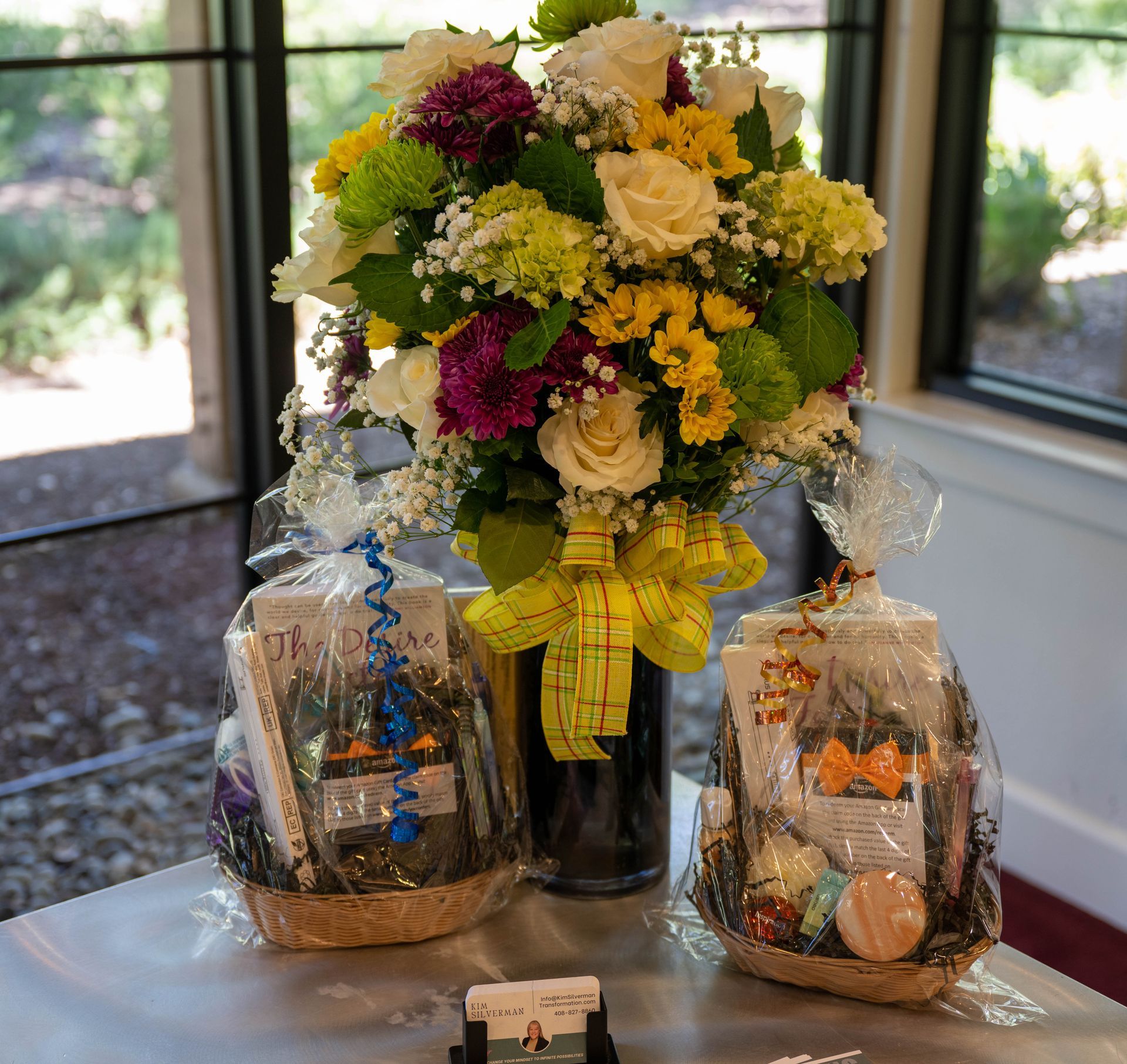 A table with two baskets and a vase of flowers on it