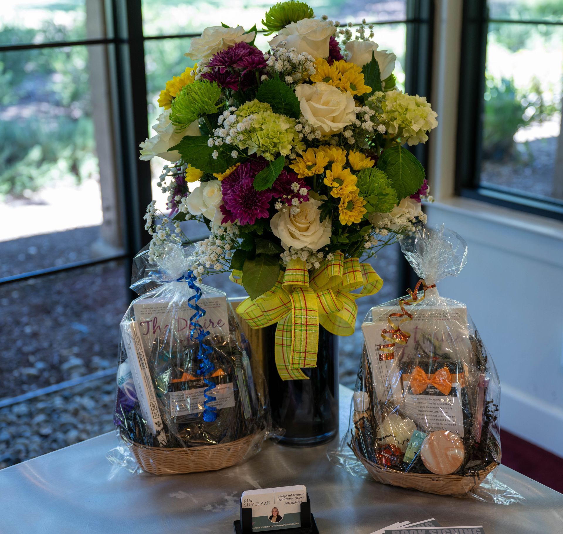 A vase of flowers sits on a table next to two baskets