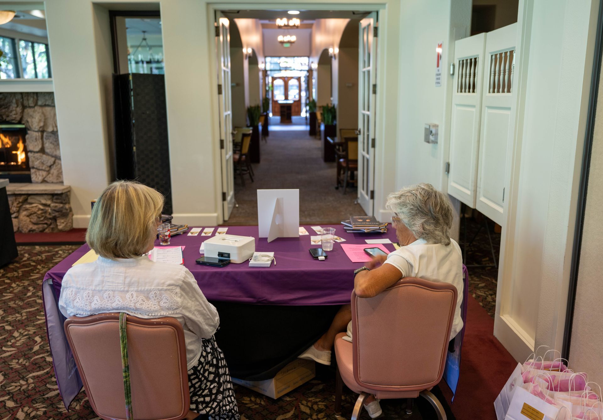 Two women are sitting at a table in a room.