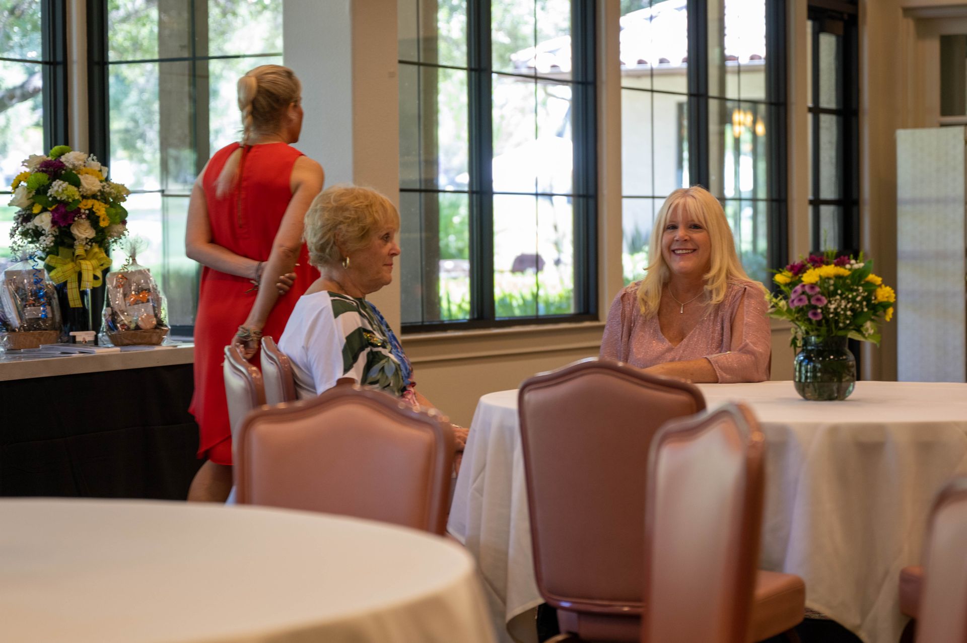 A group of women are sitting at tables in a room.