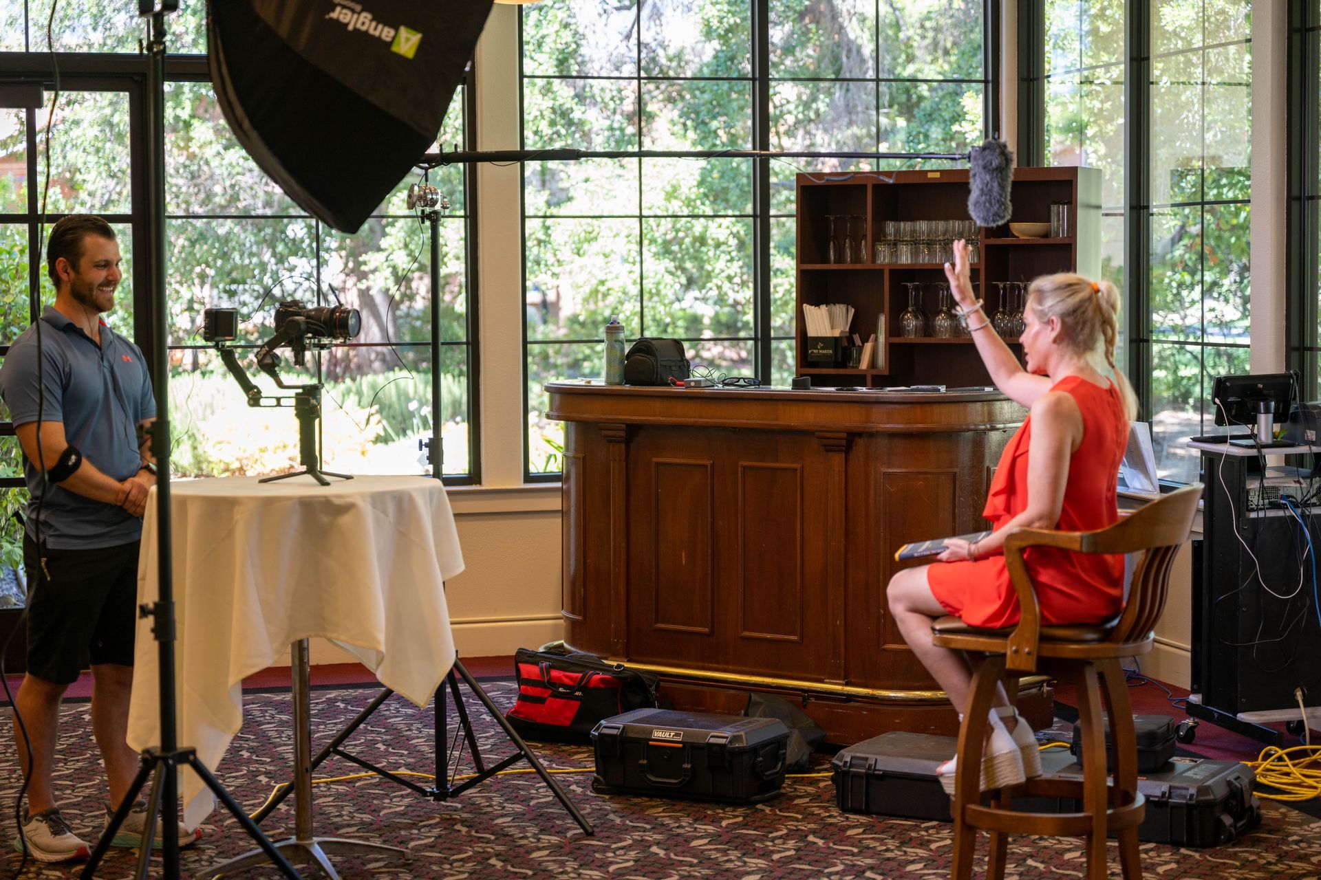 A woman in a red dress is sitting in a chair in front of a bar.