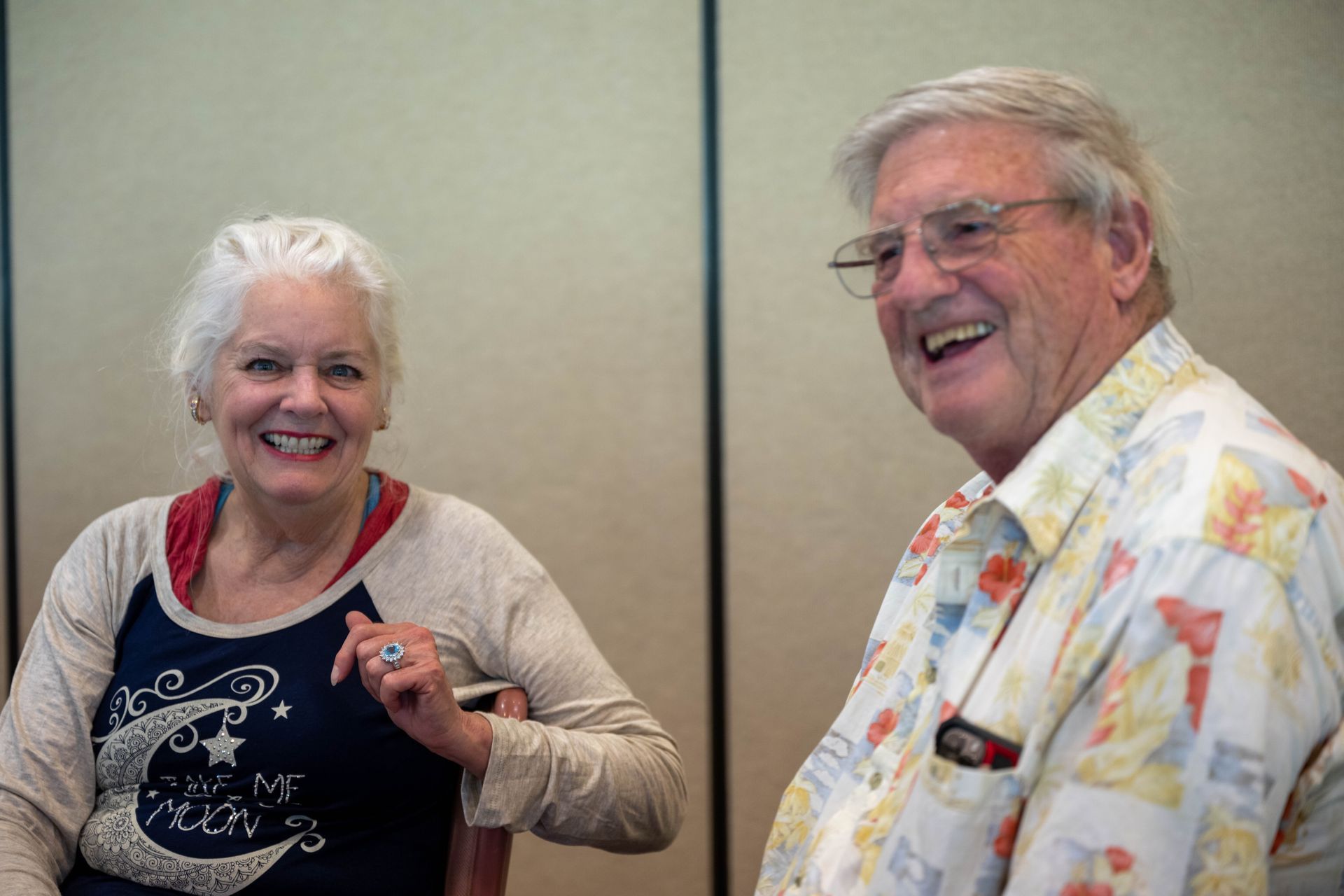 A man and a woman are sitting next to each other and smiling.