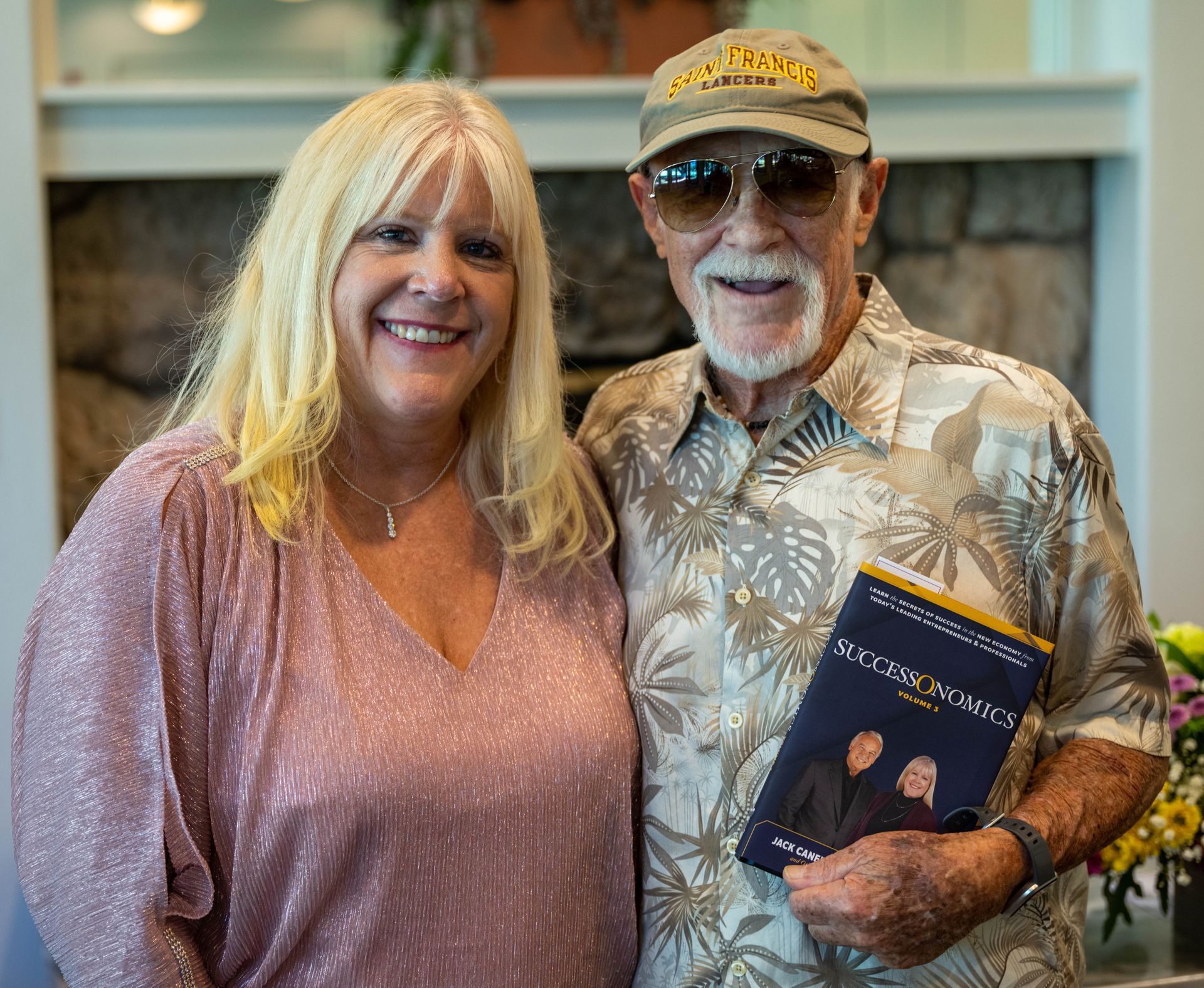 A man and Kim Silverman are posing for a picture while the man is holding a book