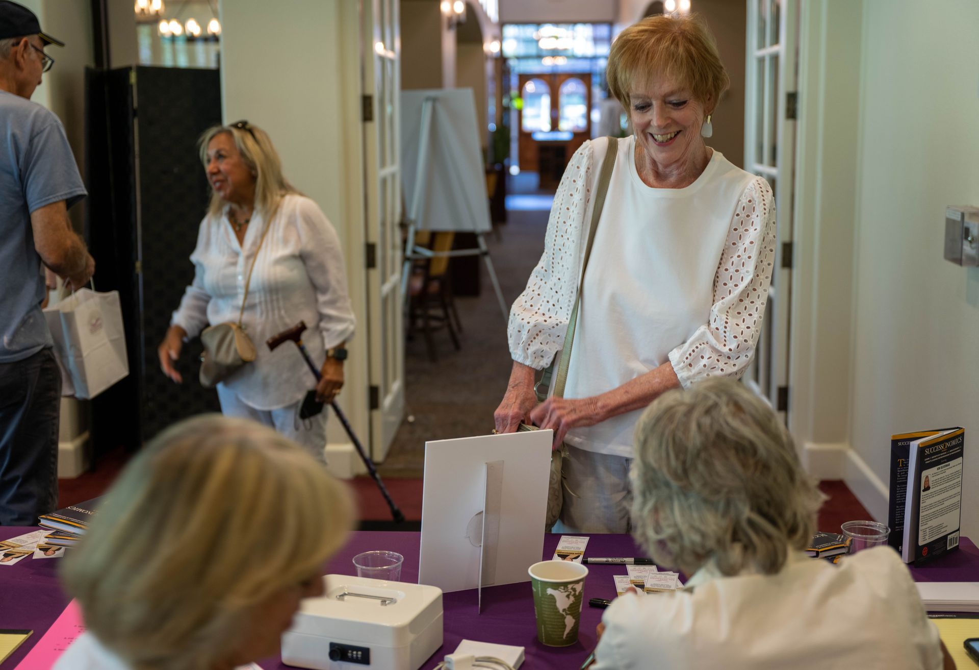 A woman is standing at a table talking to another woman.